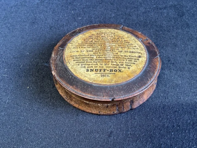 A nineteenth century snuff box dated 1824 with circular panel to cover