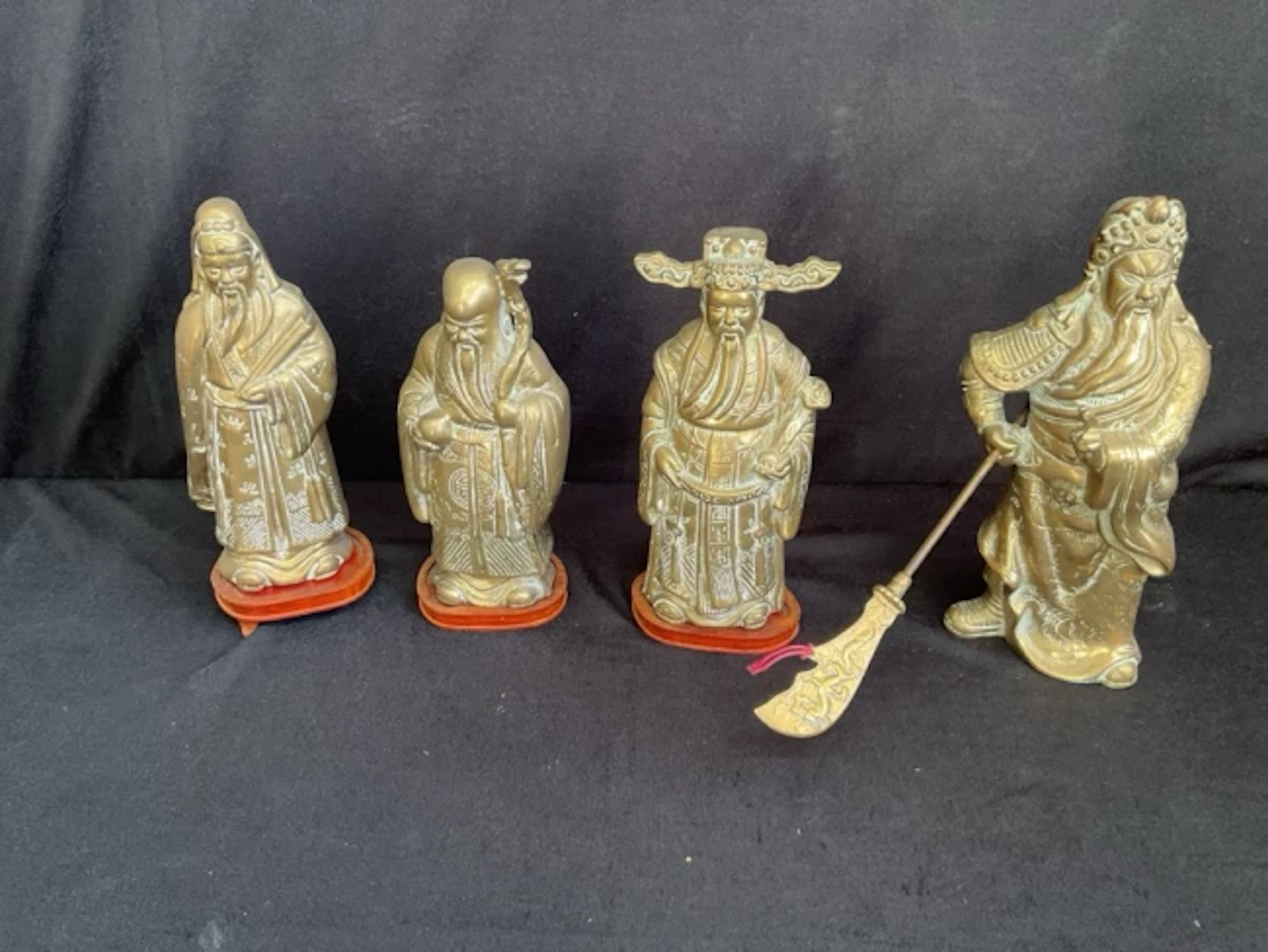 A set of Chinese cast brass figures on hardwood stands of the three
