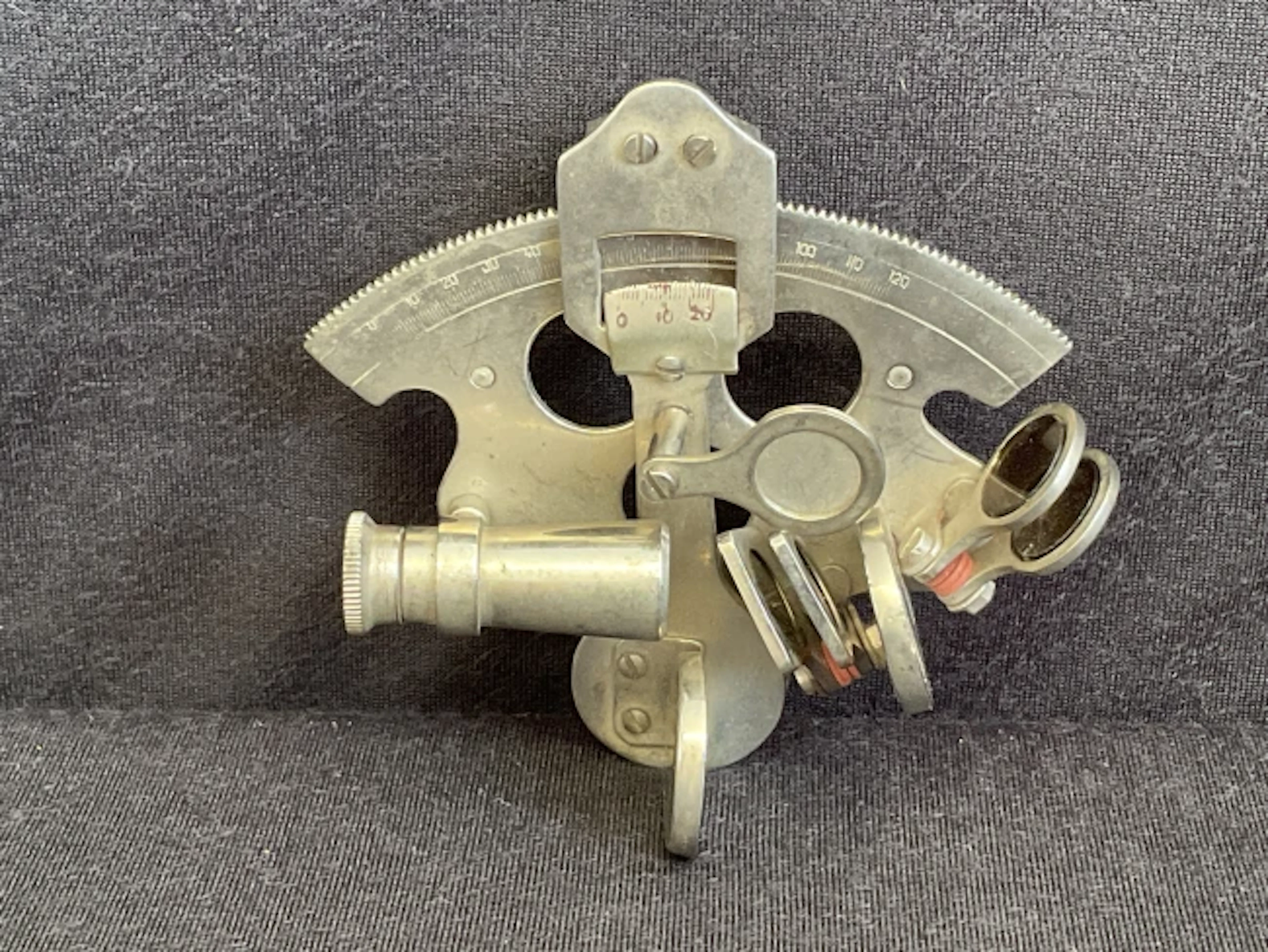 A miniature chromed brass sextant with glass filters and curved scale