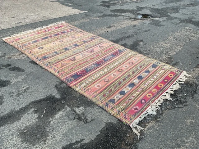 A Caucasian Soumak wool rug woven with striped bands of hooked lozenge