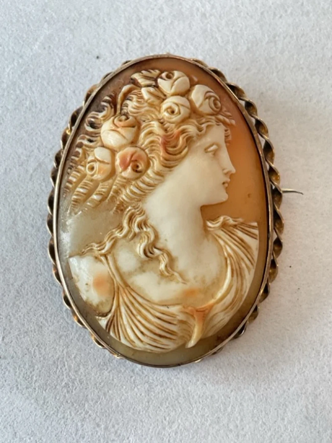 An antique shell cameo brooch of a classical lady in profile, mounted