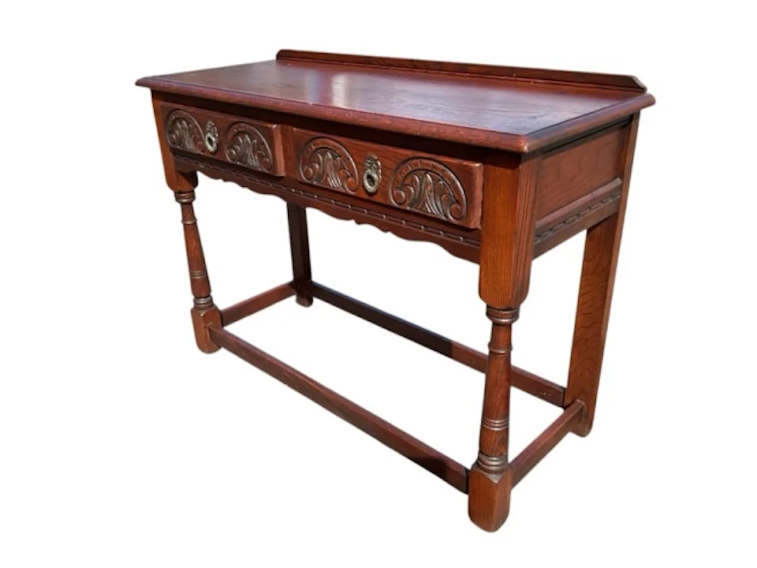 An oak side table with raised back and rectangular moulded top above