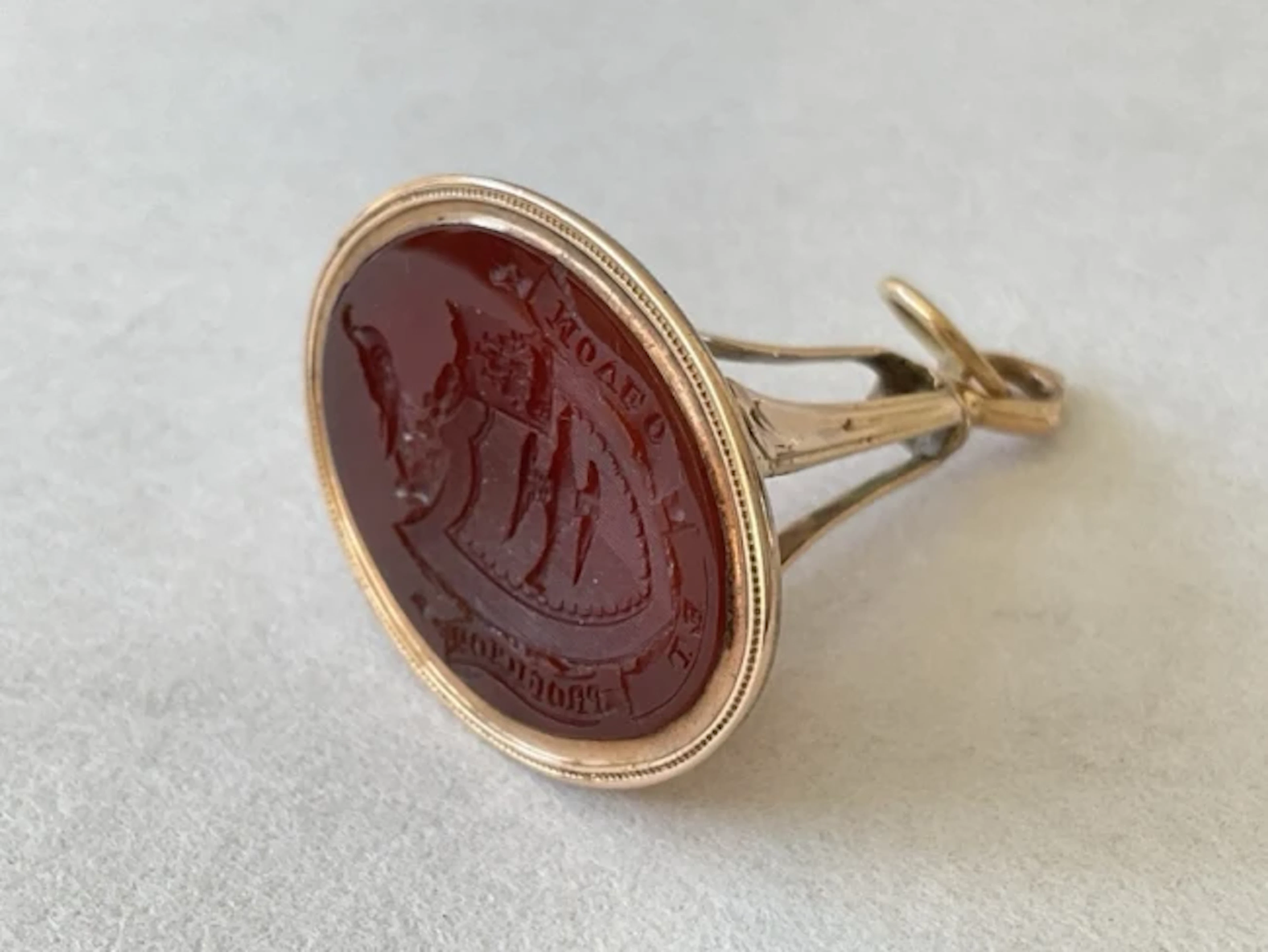 A Georgian gold agate intaglio fob seal with coat of arms and motto
