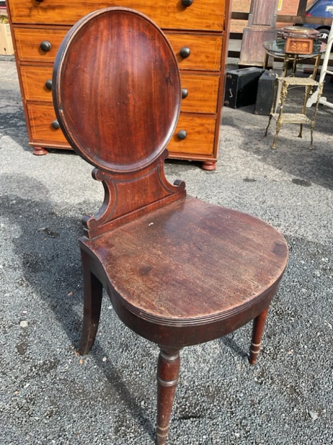A regency mahogany hall chair with solid moulded circular back on
