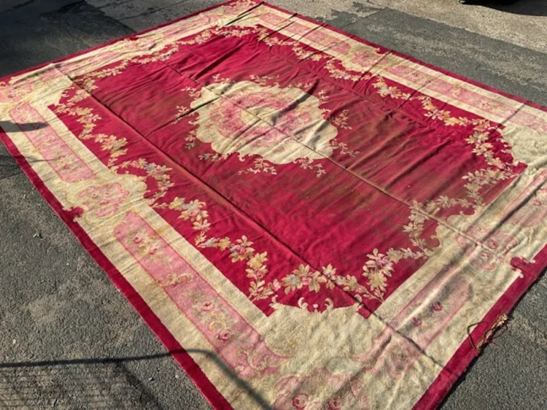 A large Donegal carpet woven in a savonnerie design with oval floral