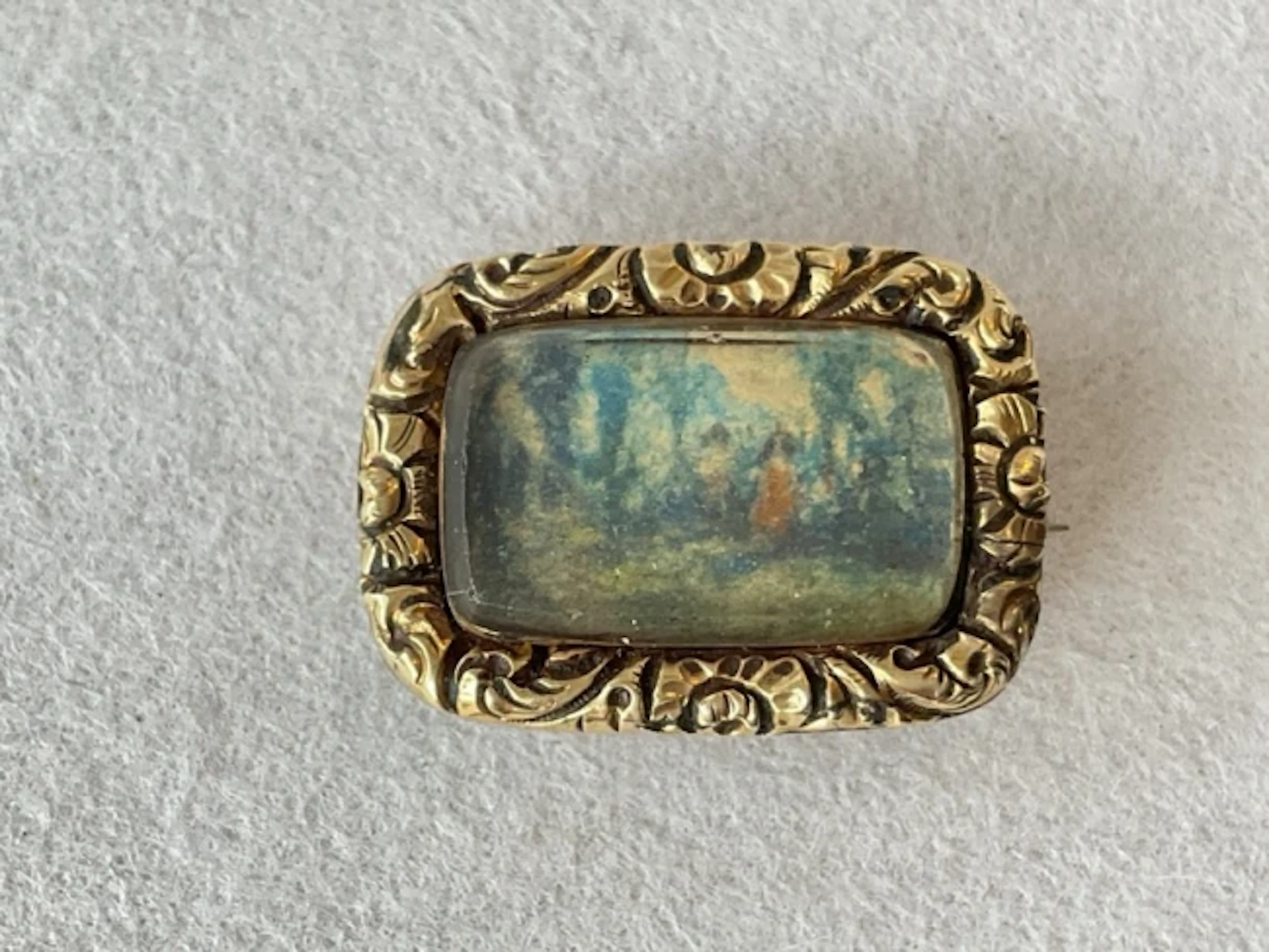 An early C19th memorial brooch with miniature painted scene behind