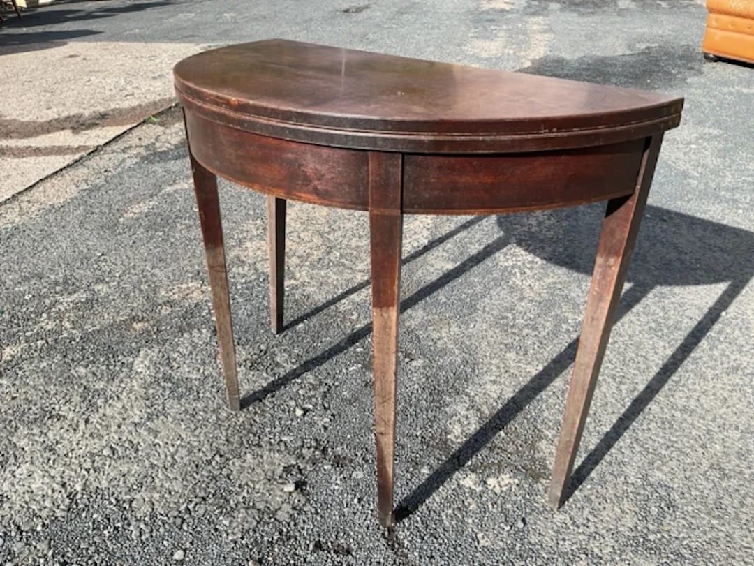 A Georgian Sheraton style mahogany foldover top tea table with demilune