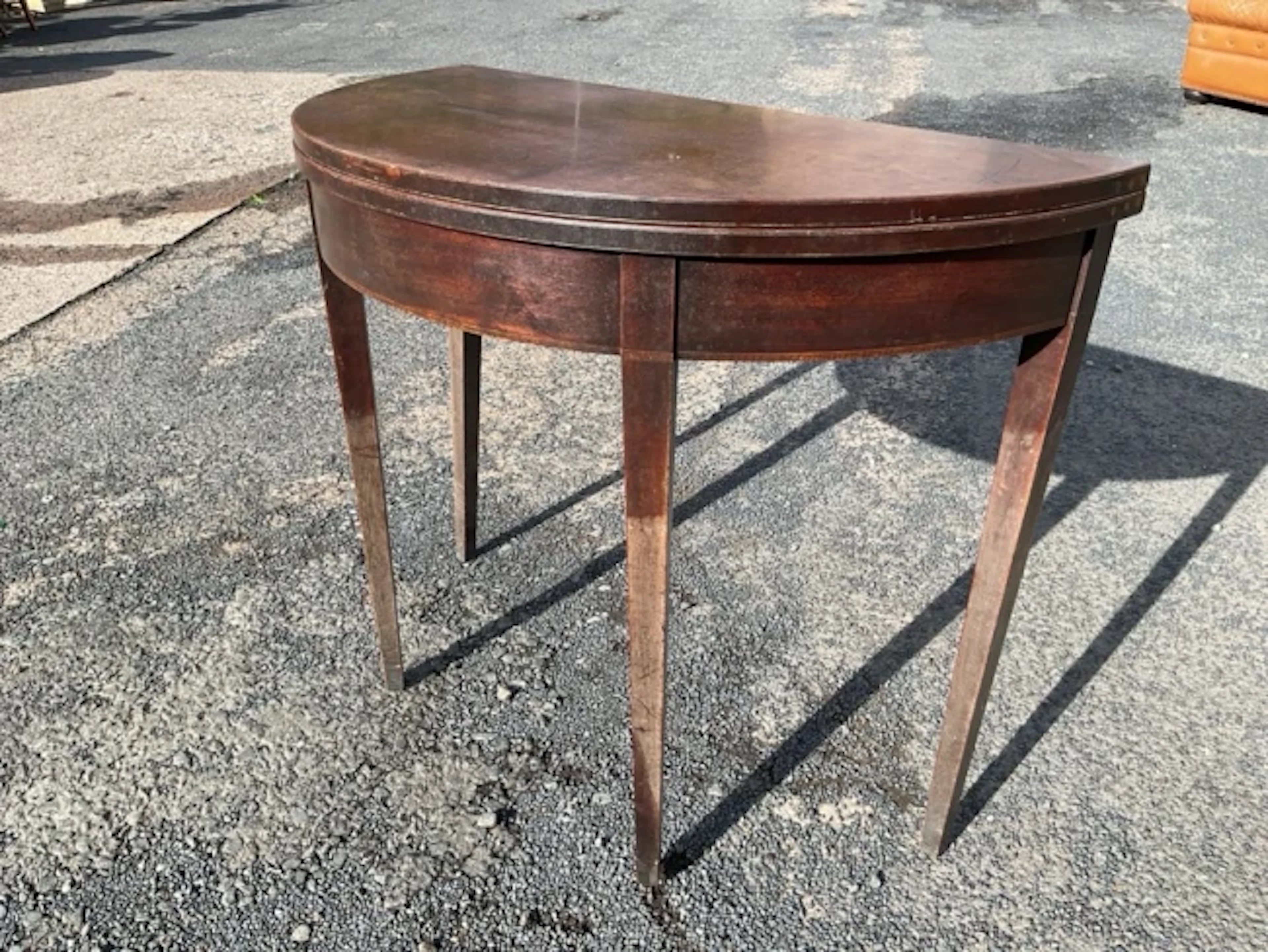 A Georgian Sheraton style mahogany foldover top tea table with demilune