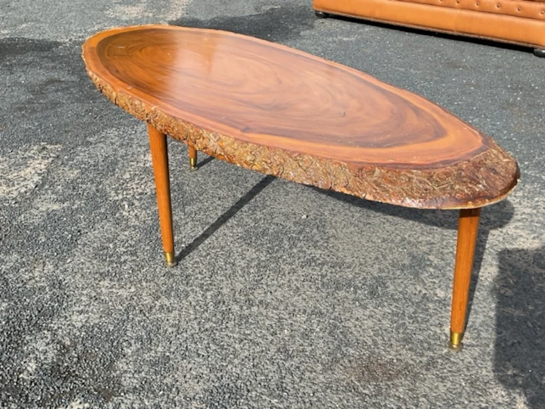 A mid-century oval hardwood coffee table, the top formed from a diagonal