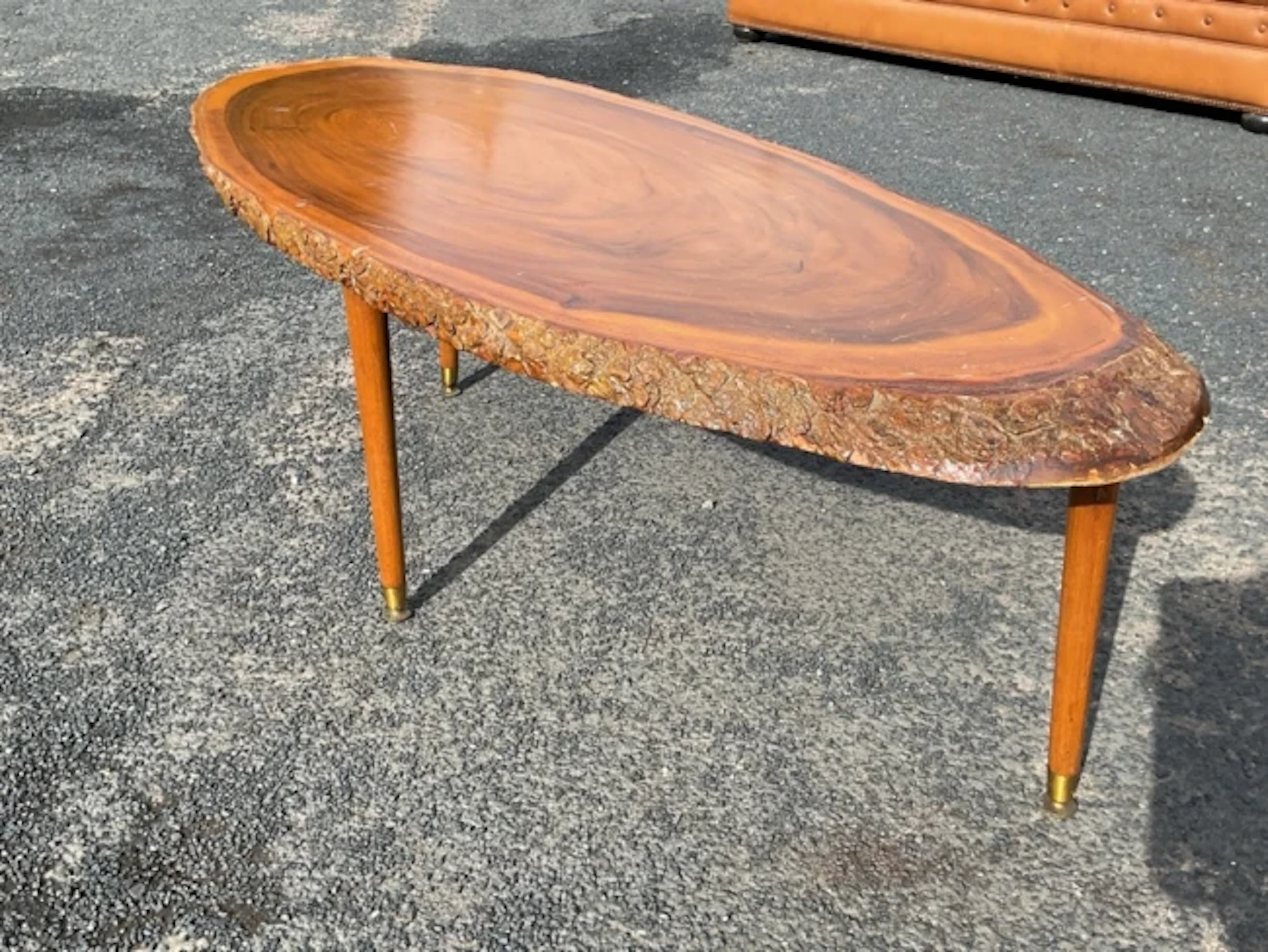 A mid-century oval hardwood coffee table, the top formed from a diagonal