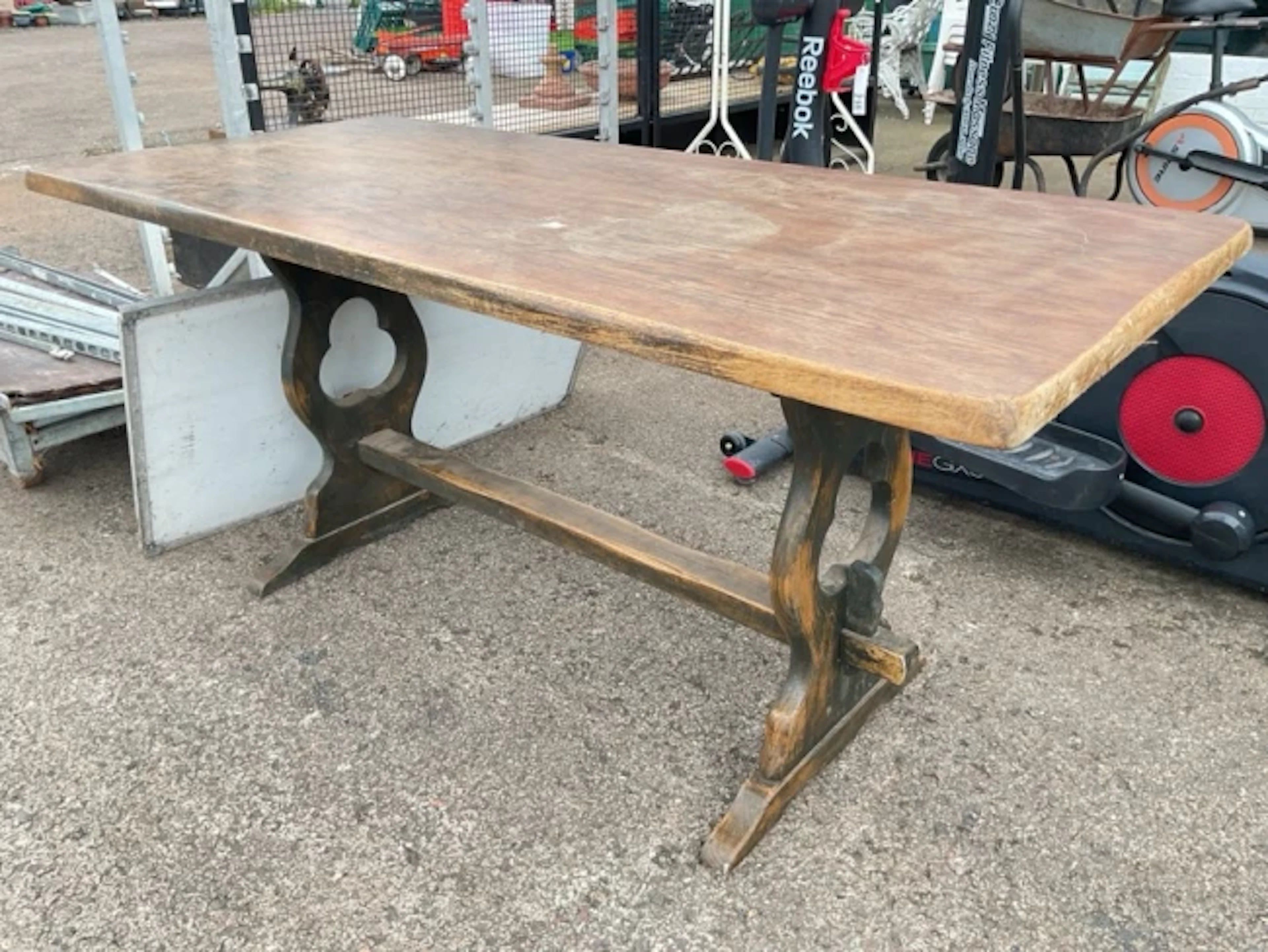 A rectangular oak style refectory table on pierced shaped trestle