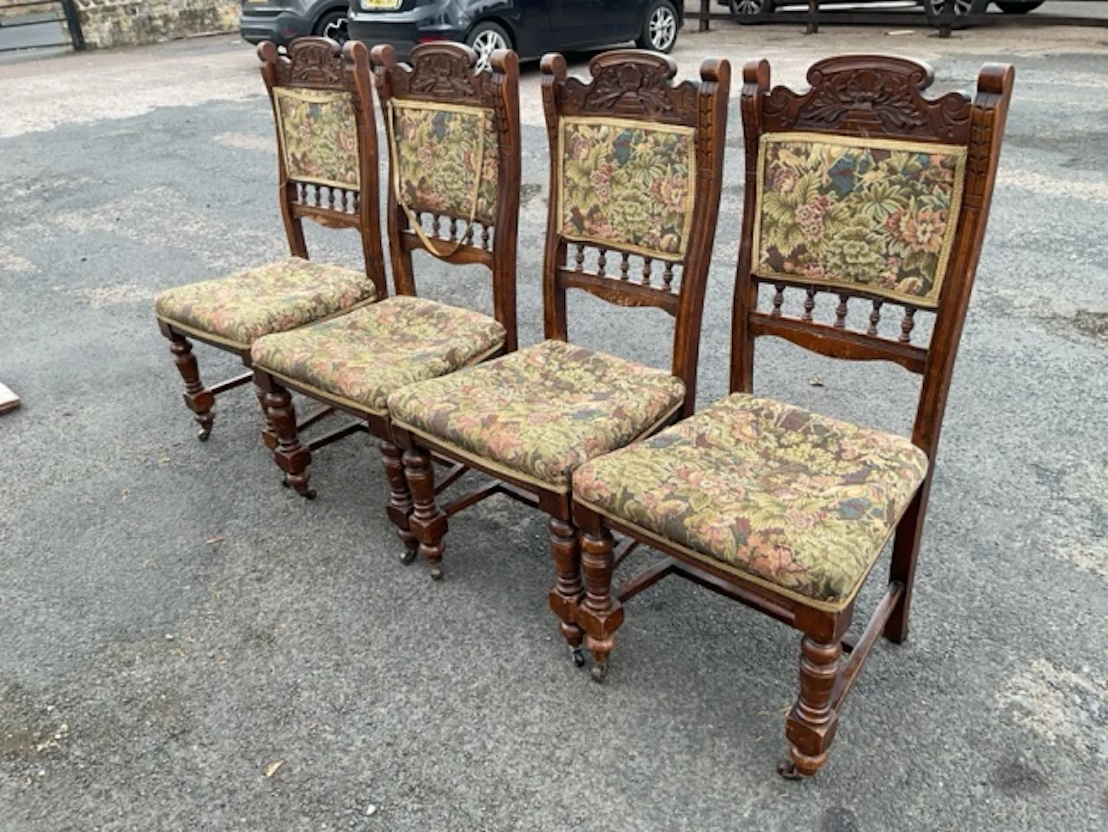 A set of four carved late Victorian dining chairs with shaped crests