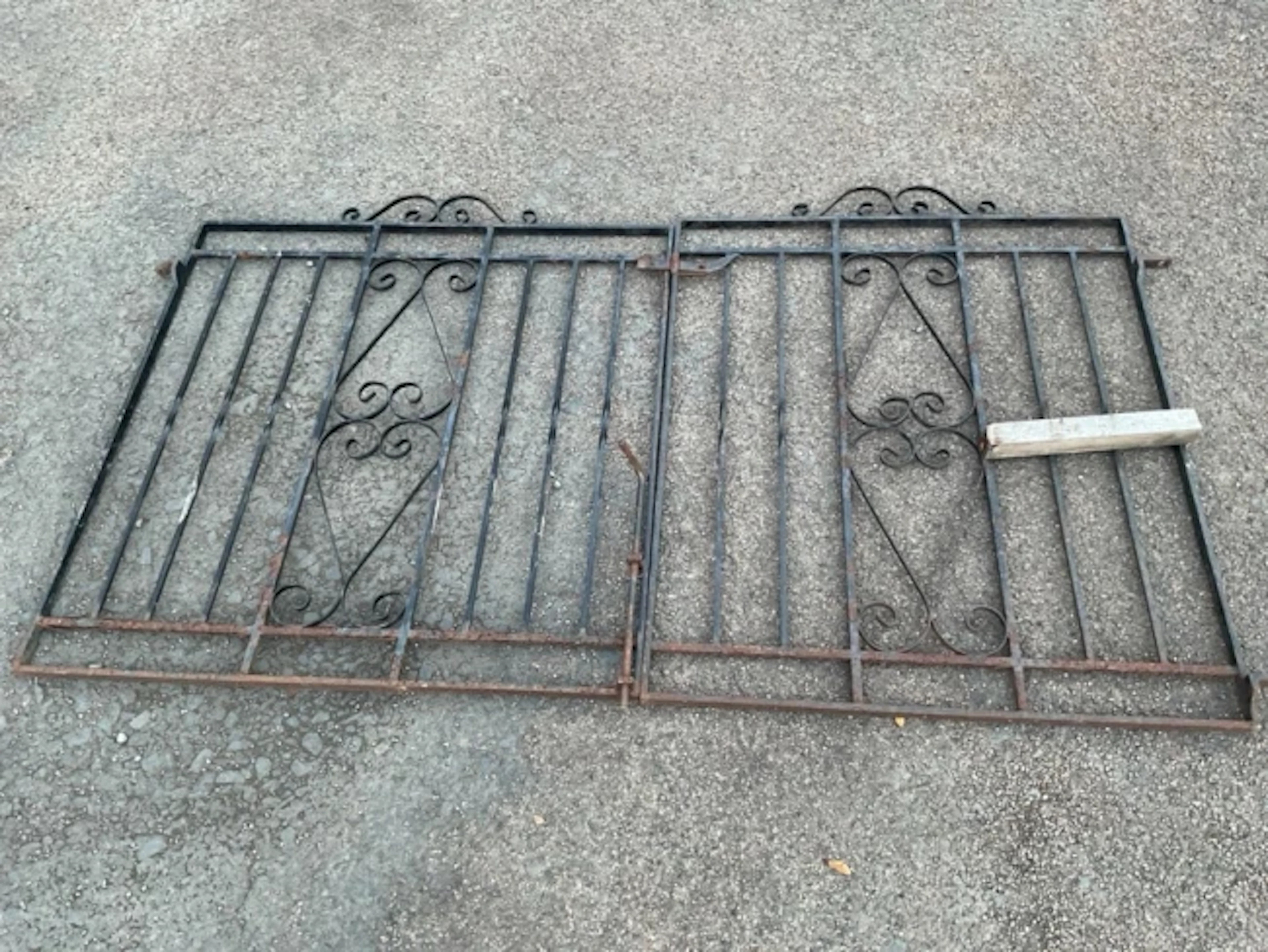 A pair of wrought iron driveway gates with square twisted spindles