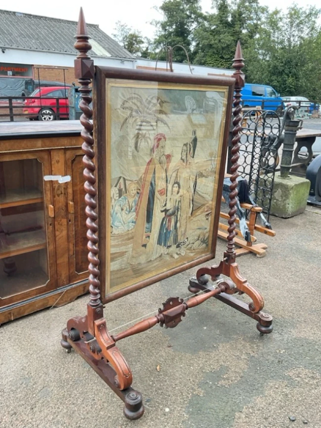 A Victorian mahogany firescreen with Egyptian style tapestry panel