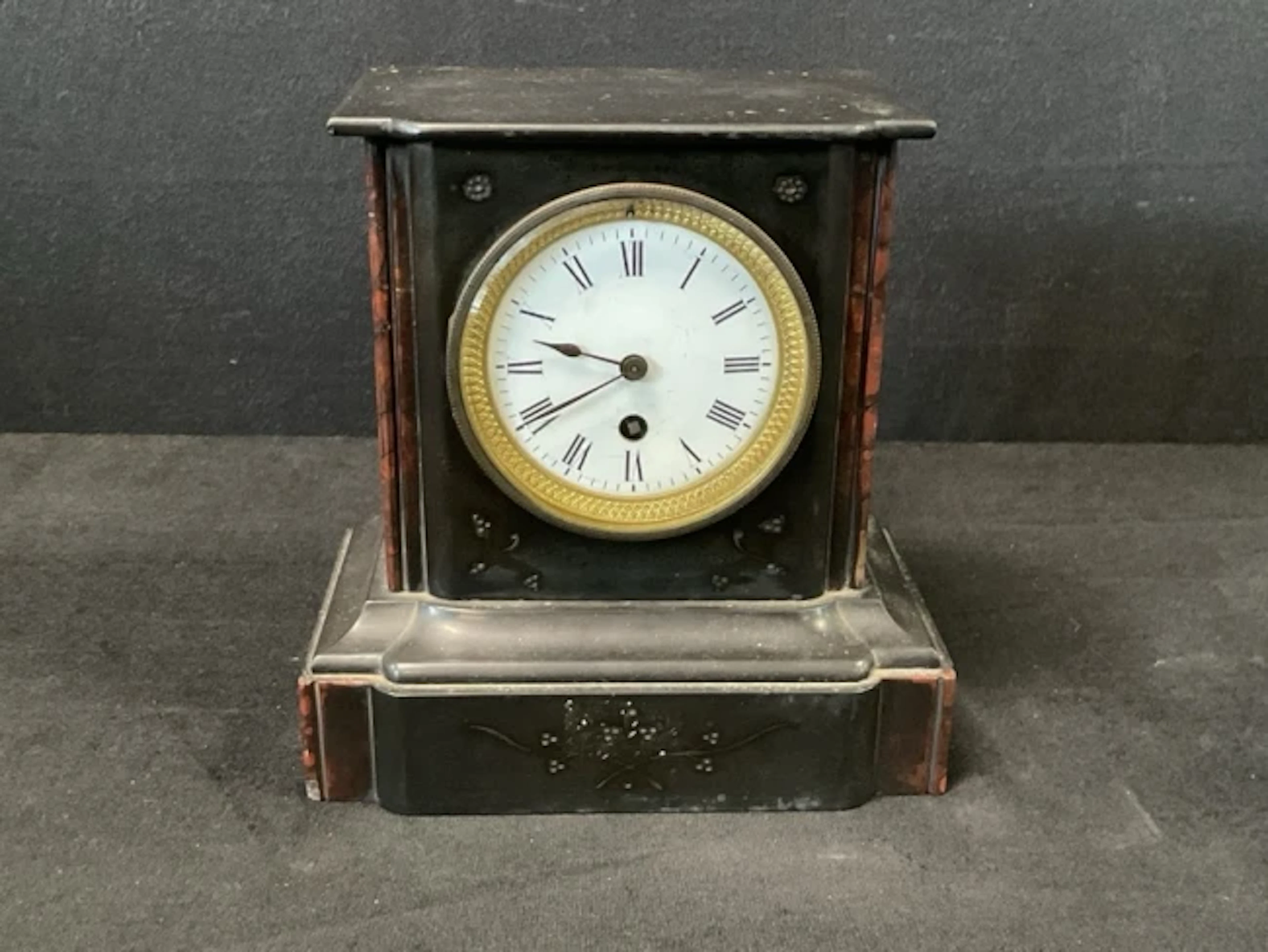 A Victorian slate mantleclock with enamelled dial, having roman chapter