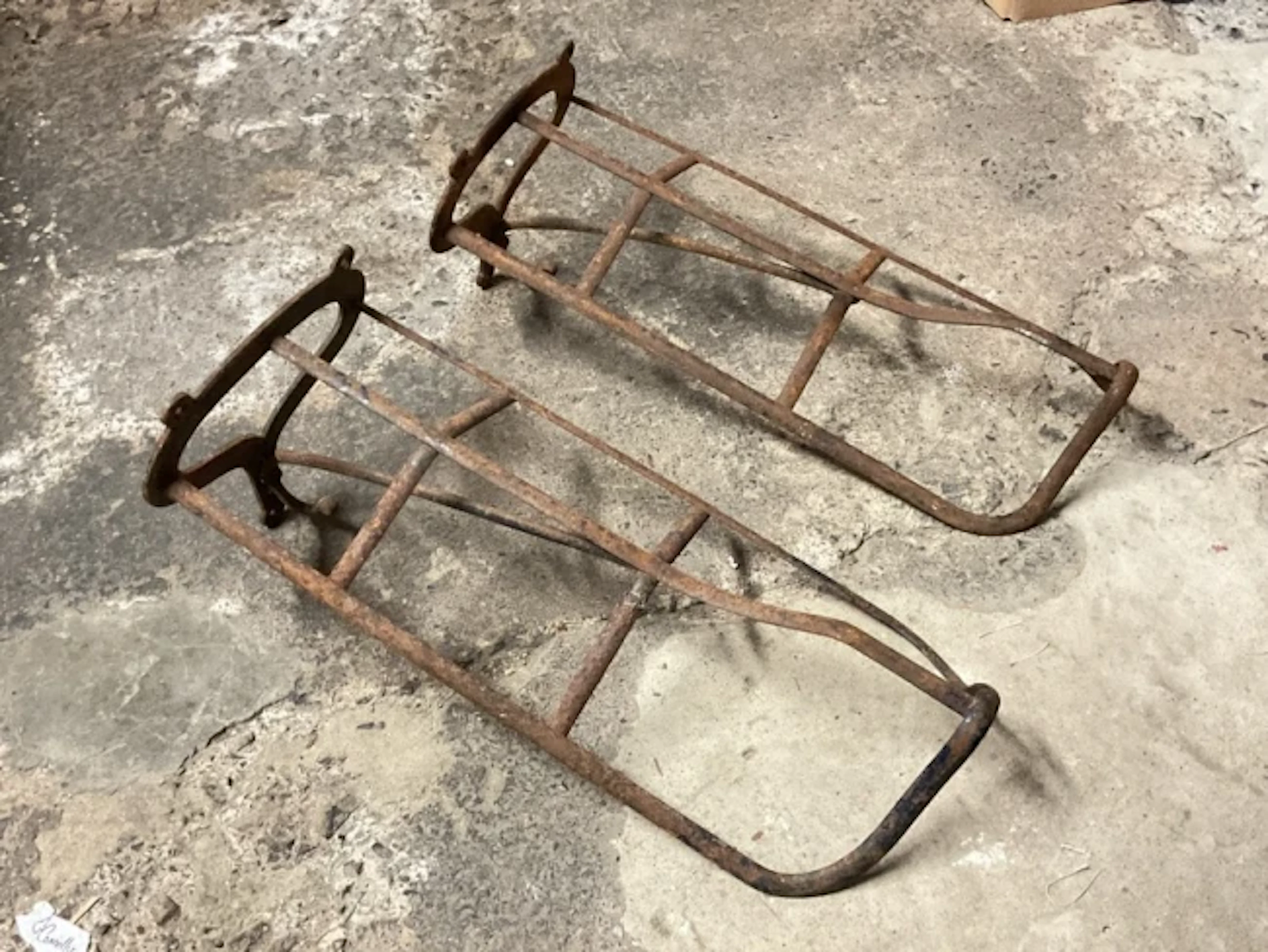 A pair of Victorian wrought iron wall mounted saddle racks with scrolled