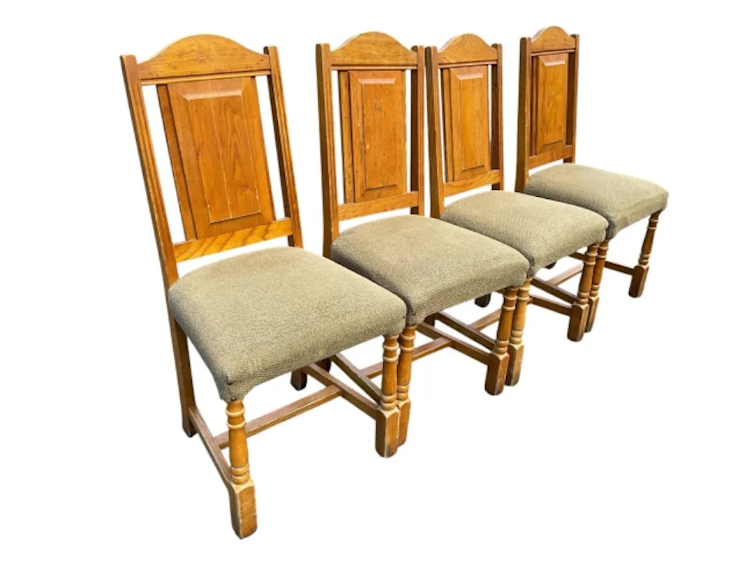 A set of four elm dining chairs with arched fielded panelled backs