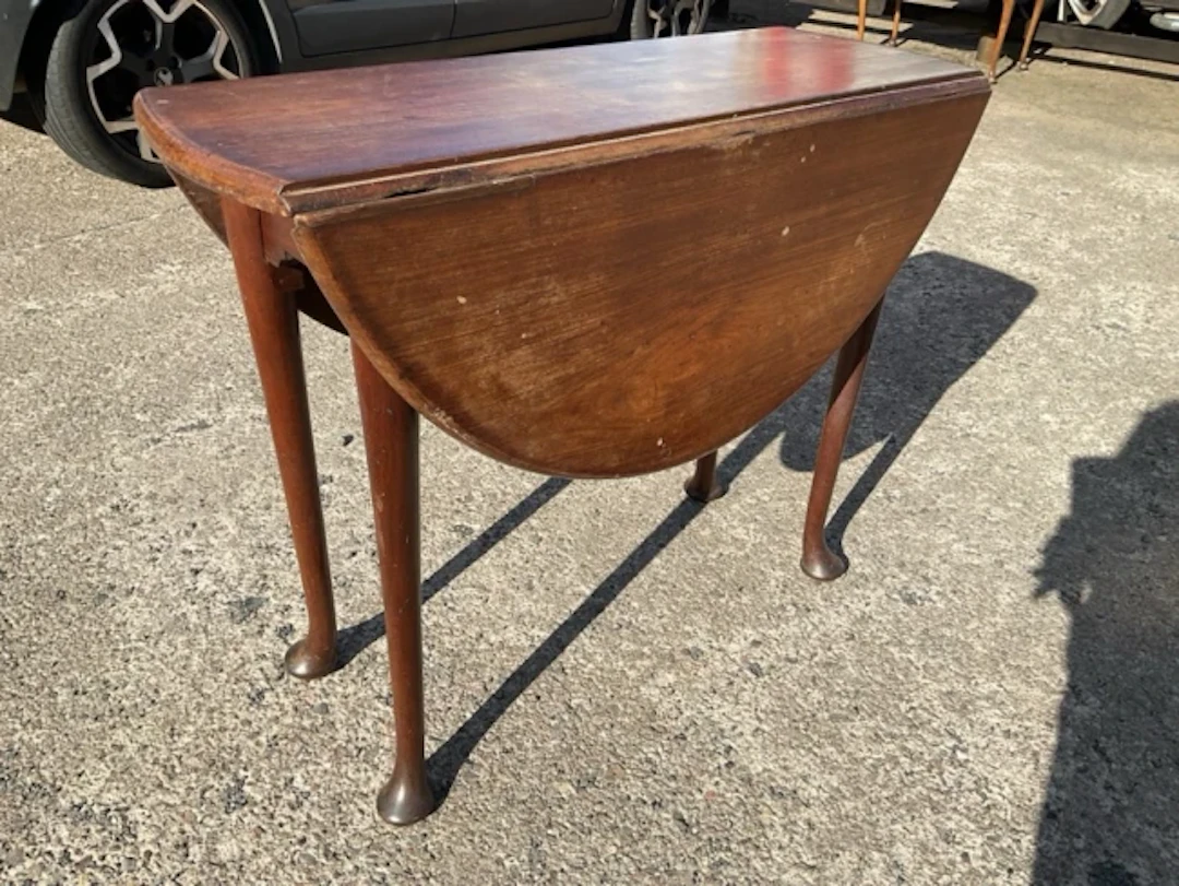 An oval Georgian mahogany dining table with two drop-leaves with rule