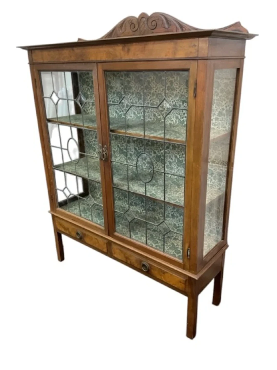 A walnut display cabinet with scroll carved crest to back above an