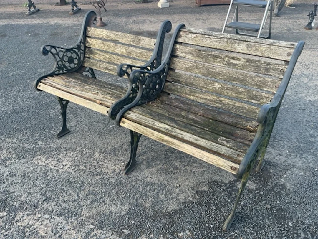 A pair of cast iron garden armchairs with wood batten backs & seats