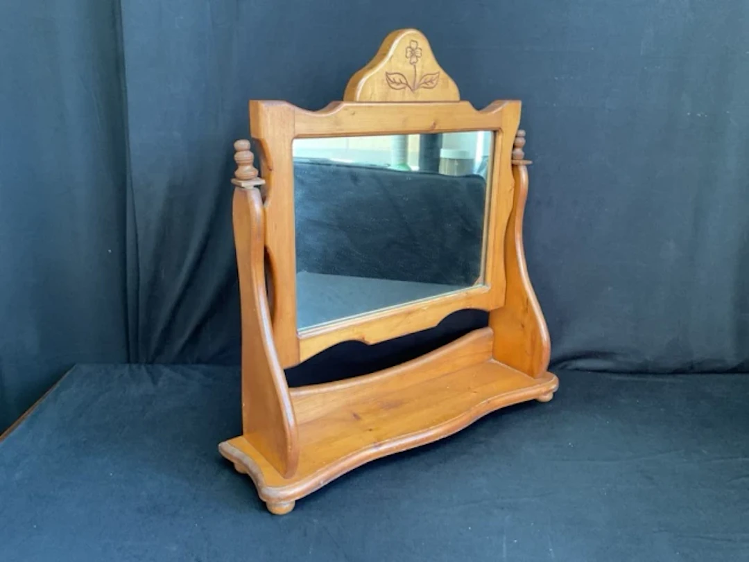 A Victorian style pine dressing table mirror with flower carved crest