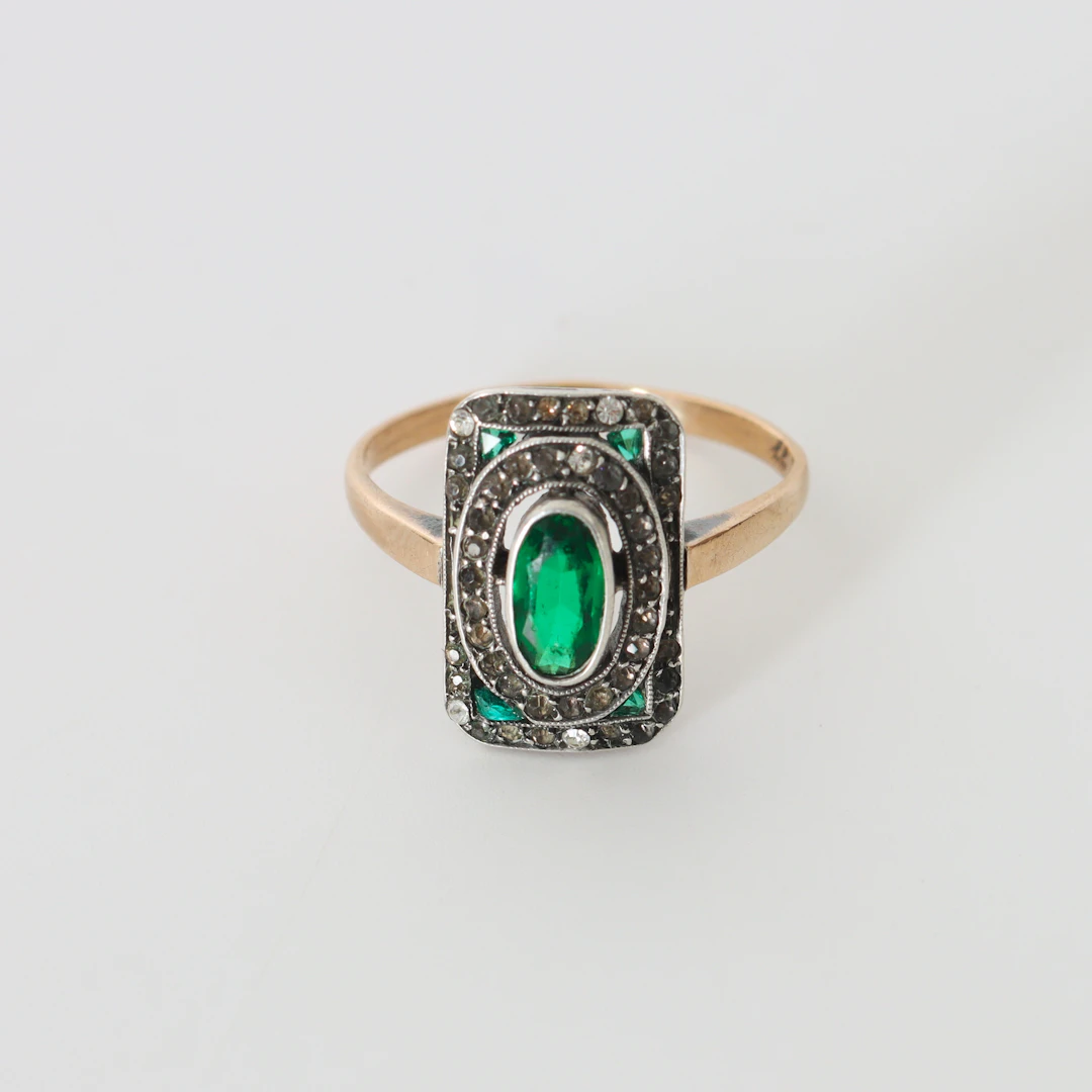 RING MED GRÖNA OCH VITA STENAR, 8K guld och silver, 1900-talets första hälft.