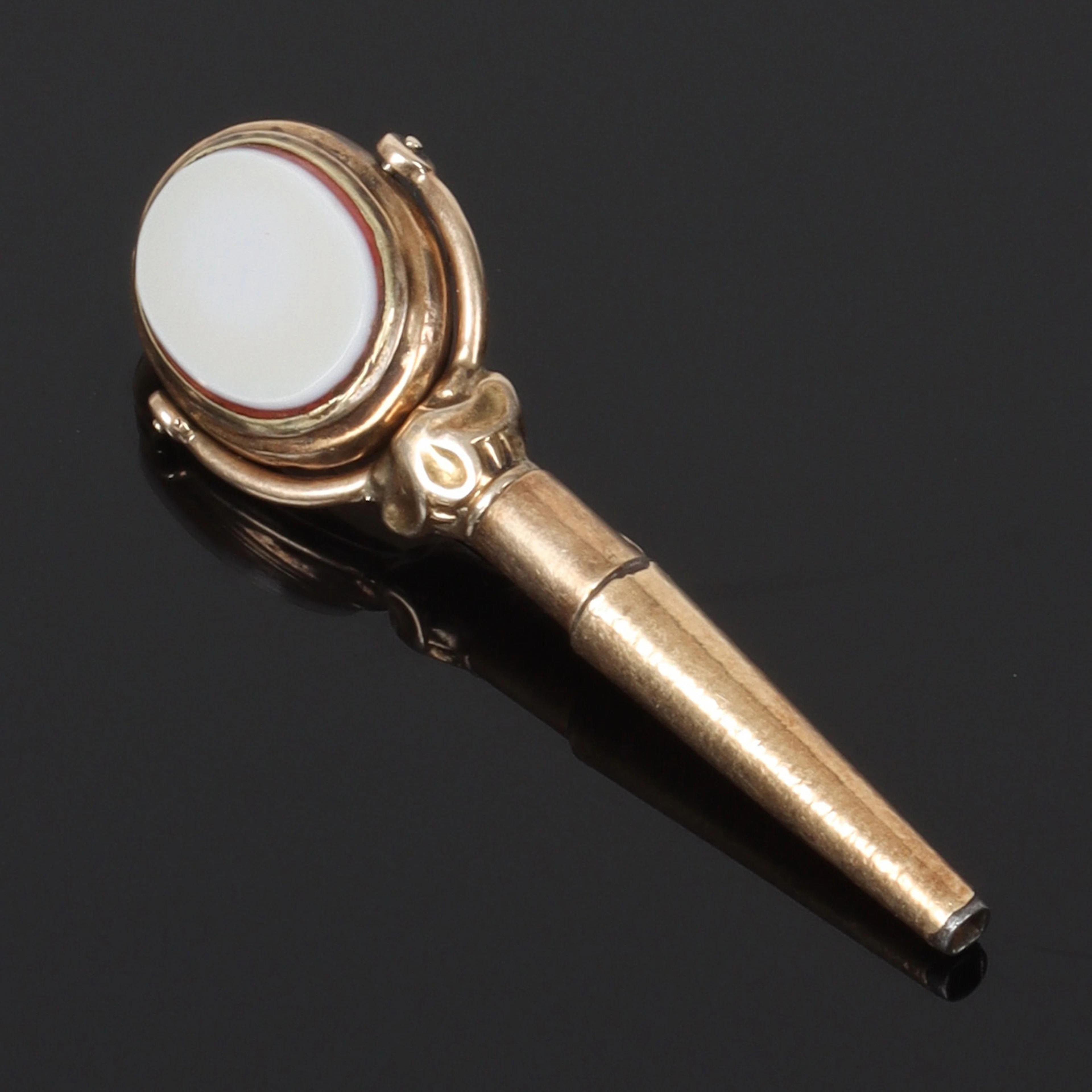 KLOCKNYCKEL, 14k guld, med karneol och cabochonslipad vit sten. 1800-tal.