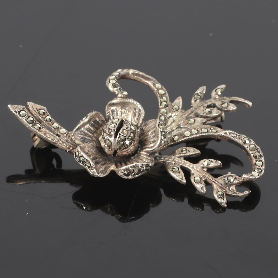 (2510-235) BROSCH, silver, blomdekor med markasiter. 1900-tal.