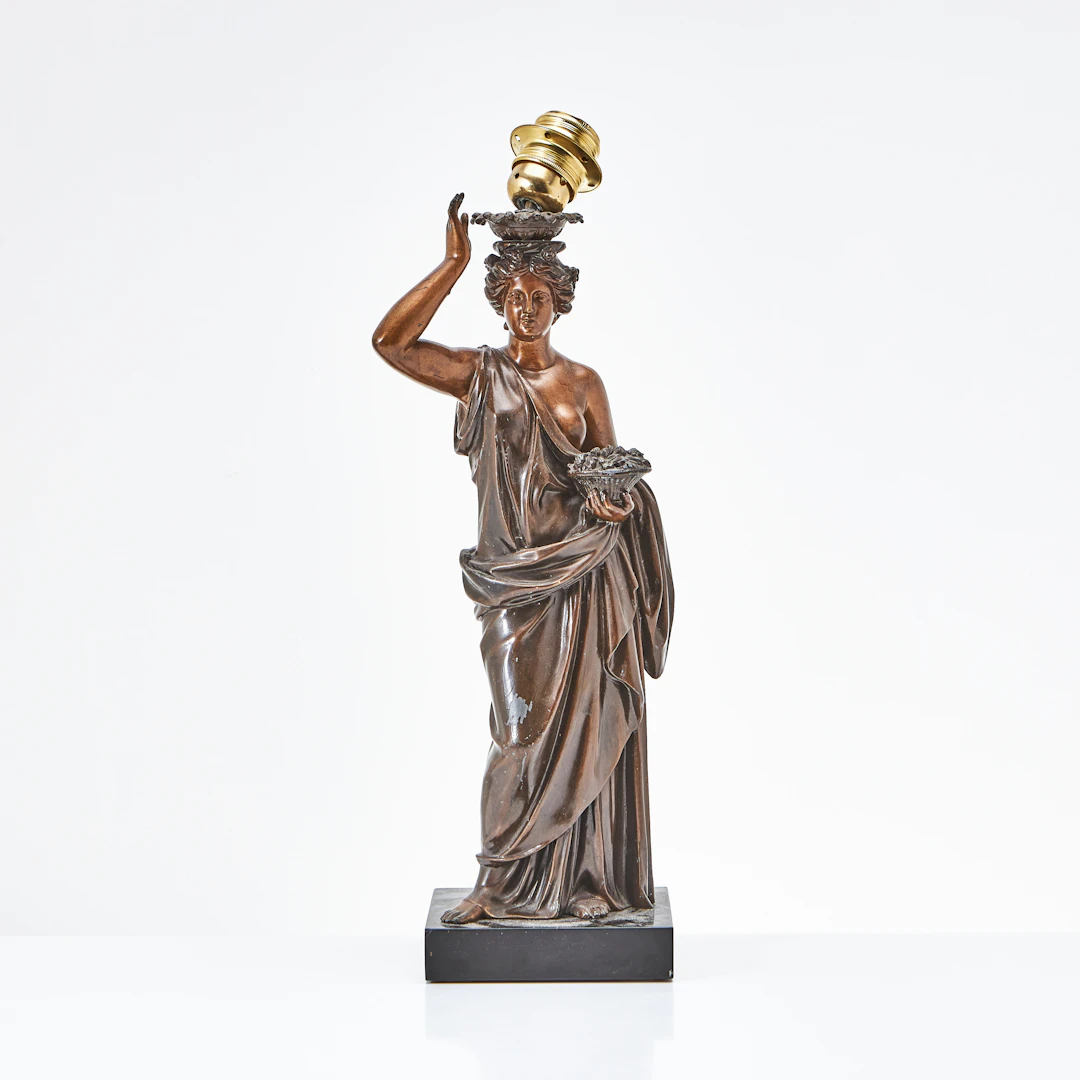 BORDSLAMPA, omkring år 1900, bronserad zink, föreställande kvinna med blomkorg.