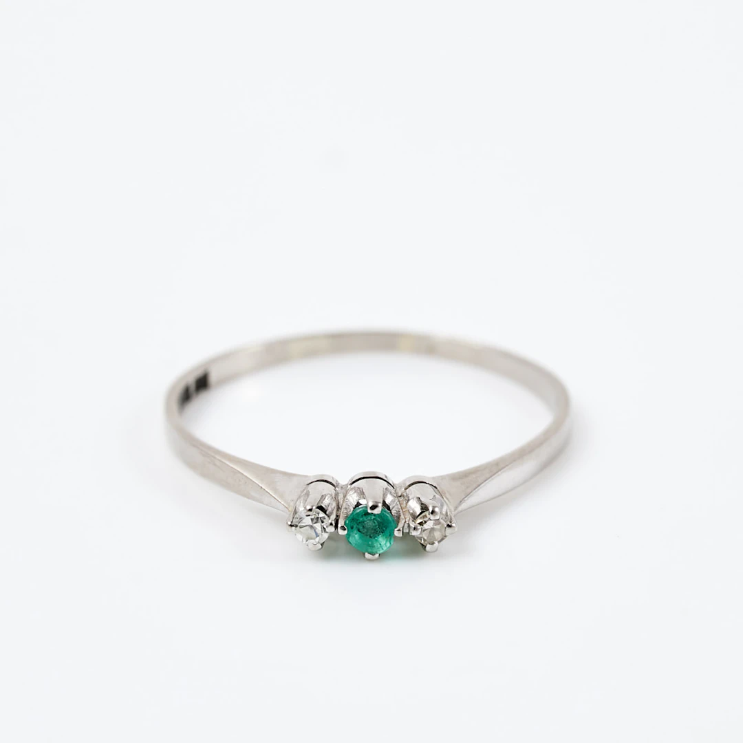 RING, 18 k vitguld, 1 fasettslipad smaragd, flankerad av 2 åttkantslipade