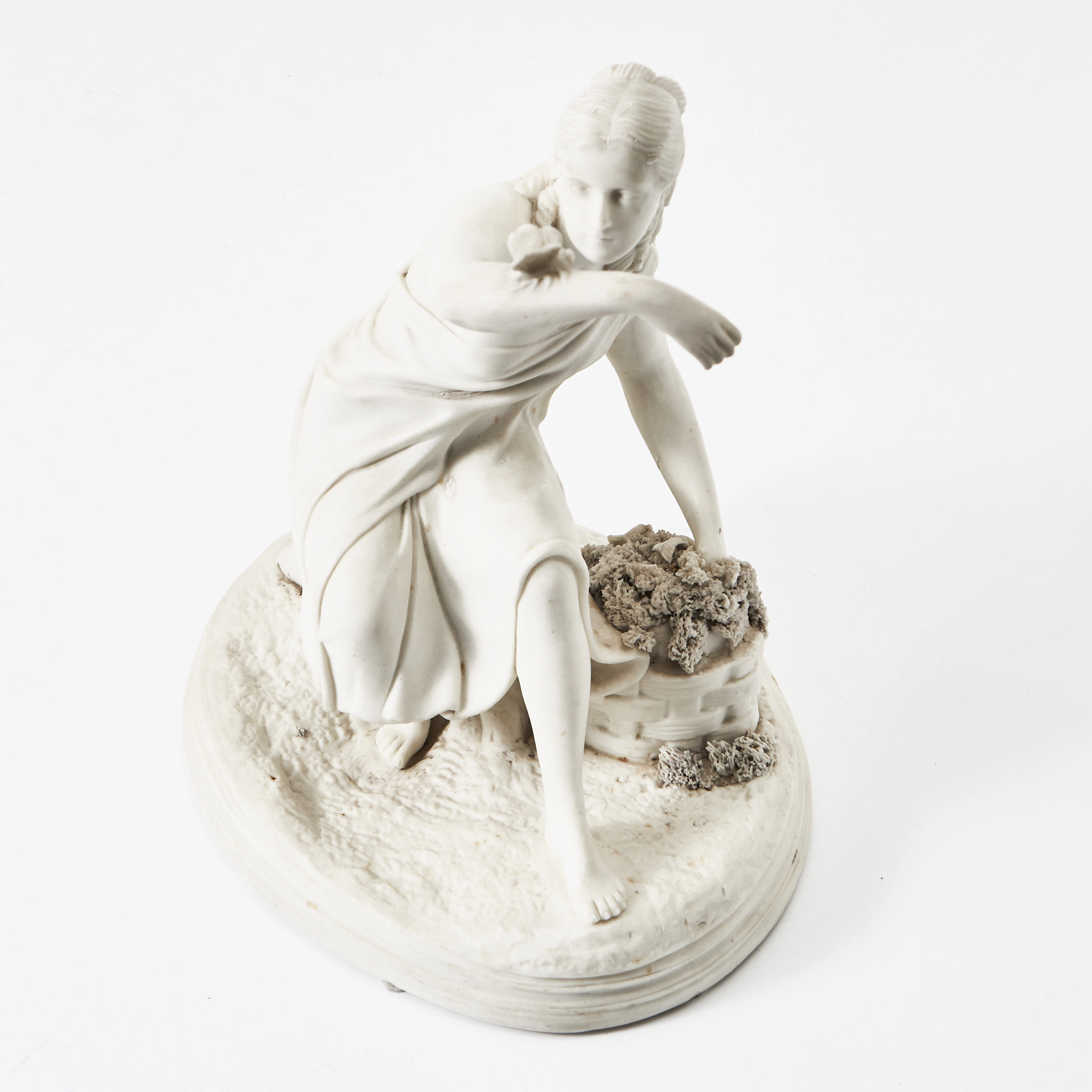 FIGURIN, parian, sittande kvinnofigur med en fjäril på armen, märkt