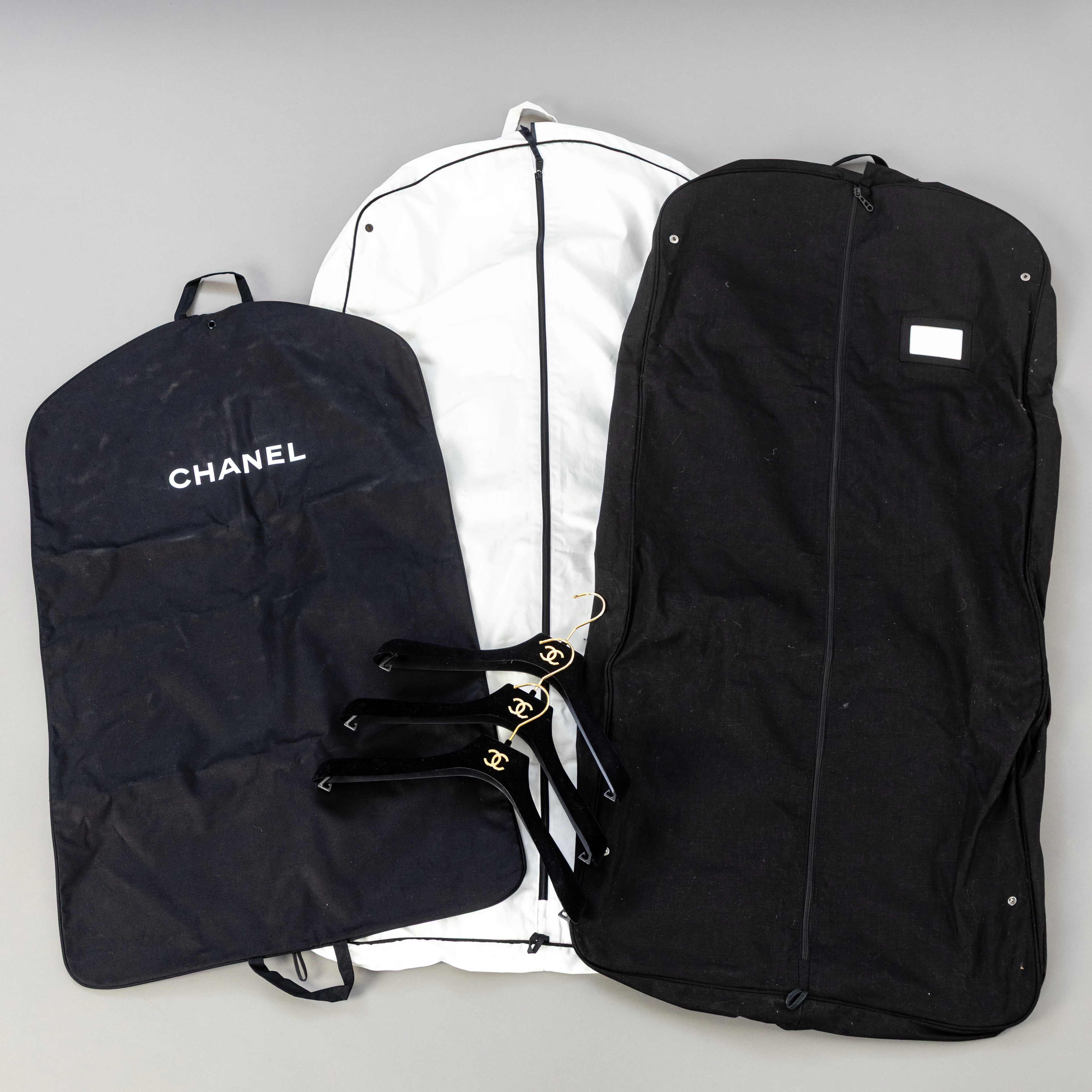 CHANEL. 3 Kleidersäcke und 3 Kleiderbügel (6).