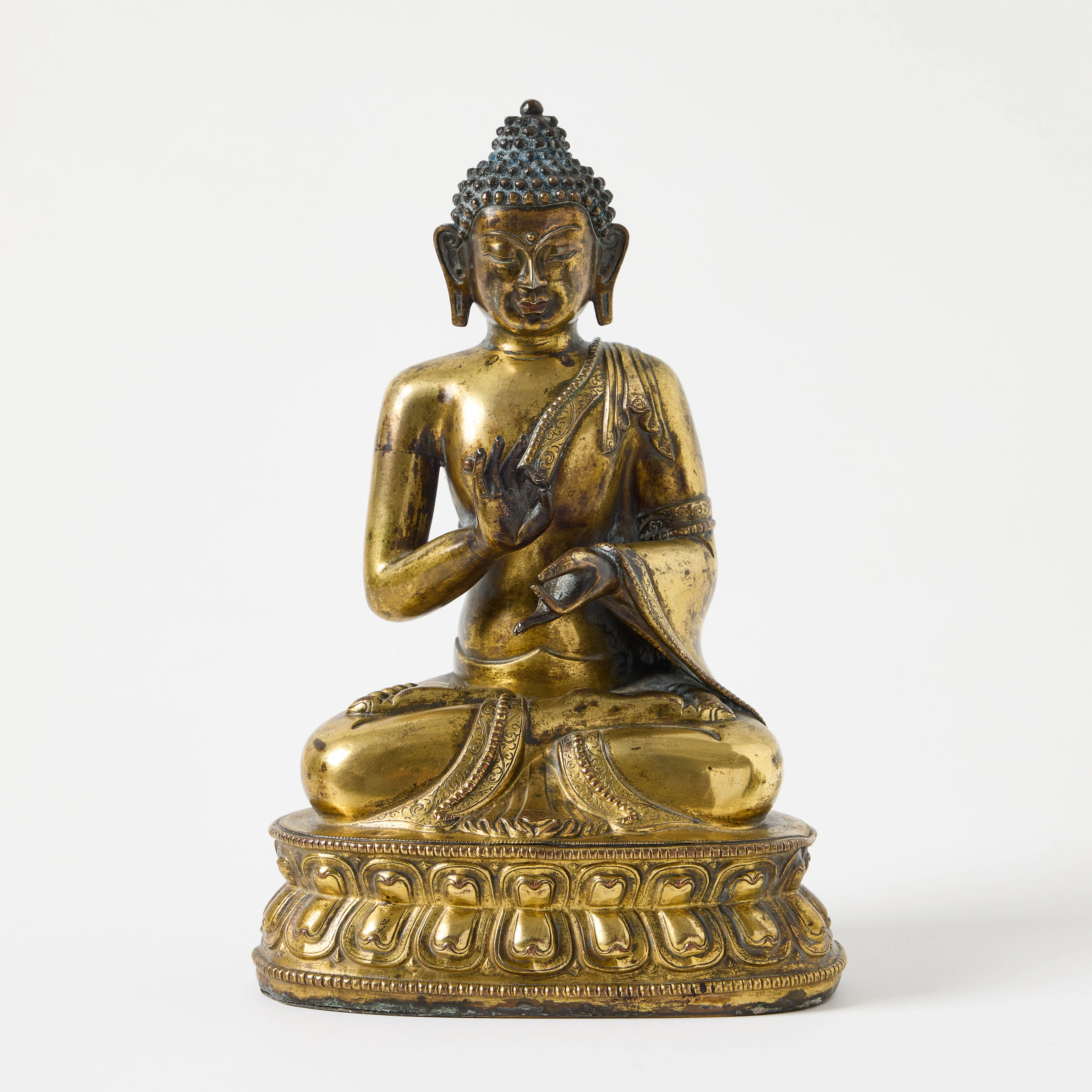 A Tibetan Gilt Copper Repoussé Figure of Dipankara Buddha.