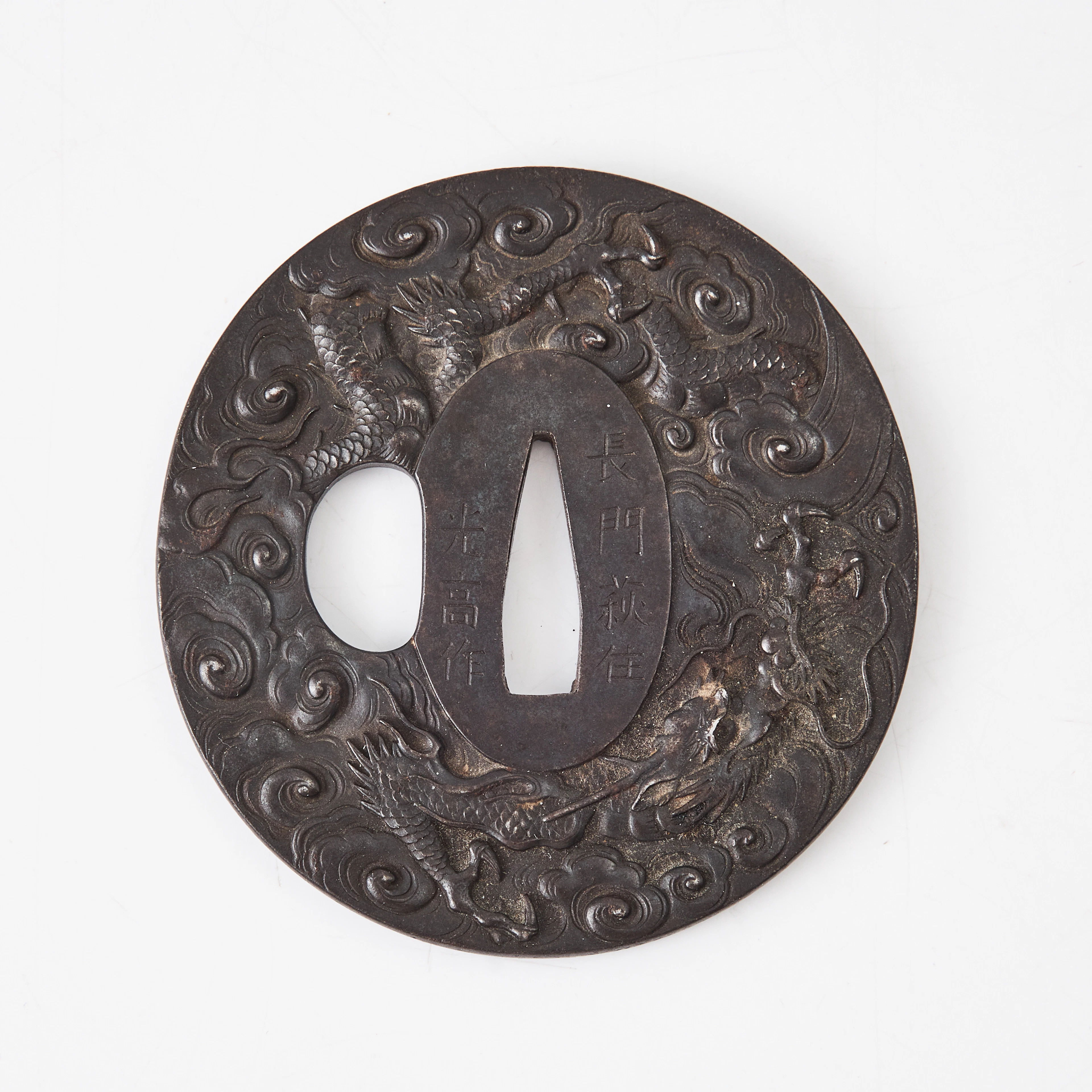TSUBA, järn, Japan, omkring 1900, reliefdekor av drakar bland moln