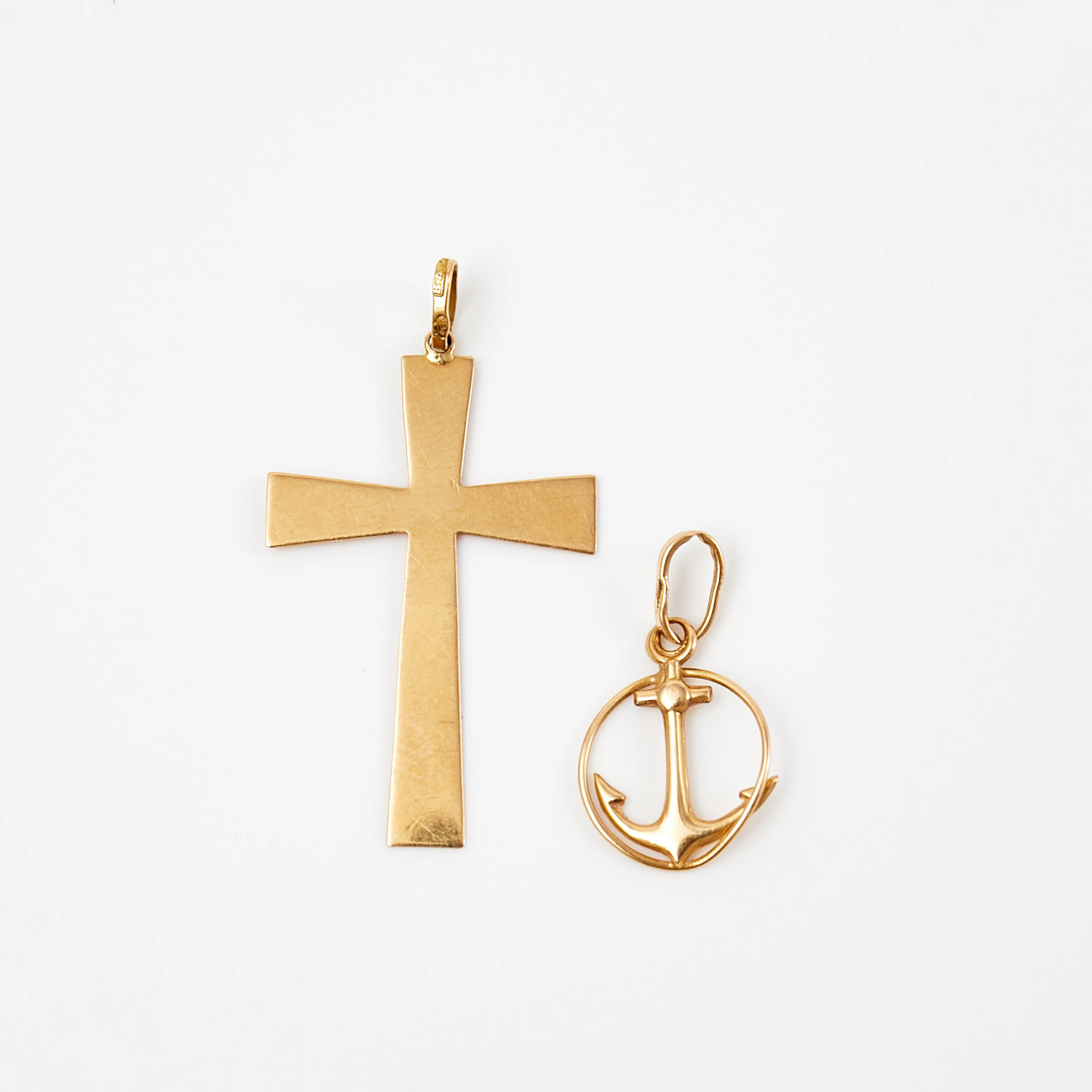 HÄNGEN, 2 styck, 18 k guld, i form av kors samt ankare, 1900-tal.