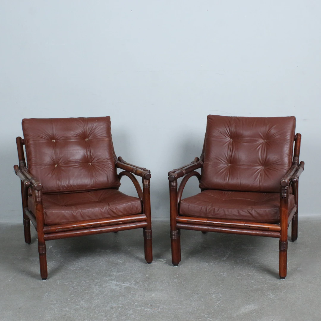 Paar Lounge-Sessel aus gebeiztem Bambus und Rattan mit braunen Lederpolstern.