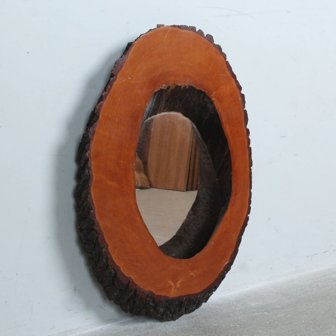 Wandspiegel mit Baumscheibenrahmen.