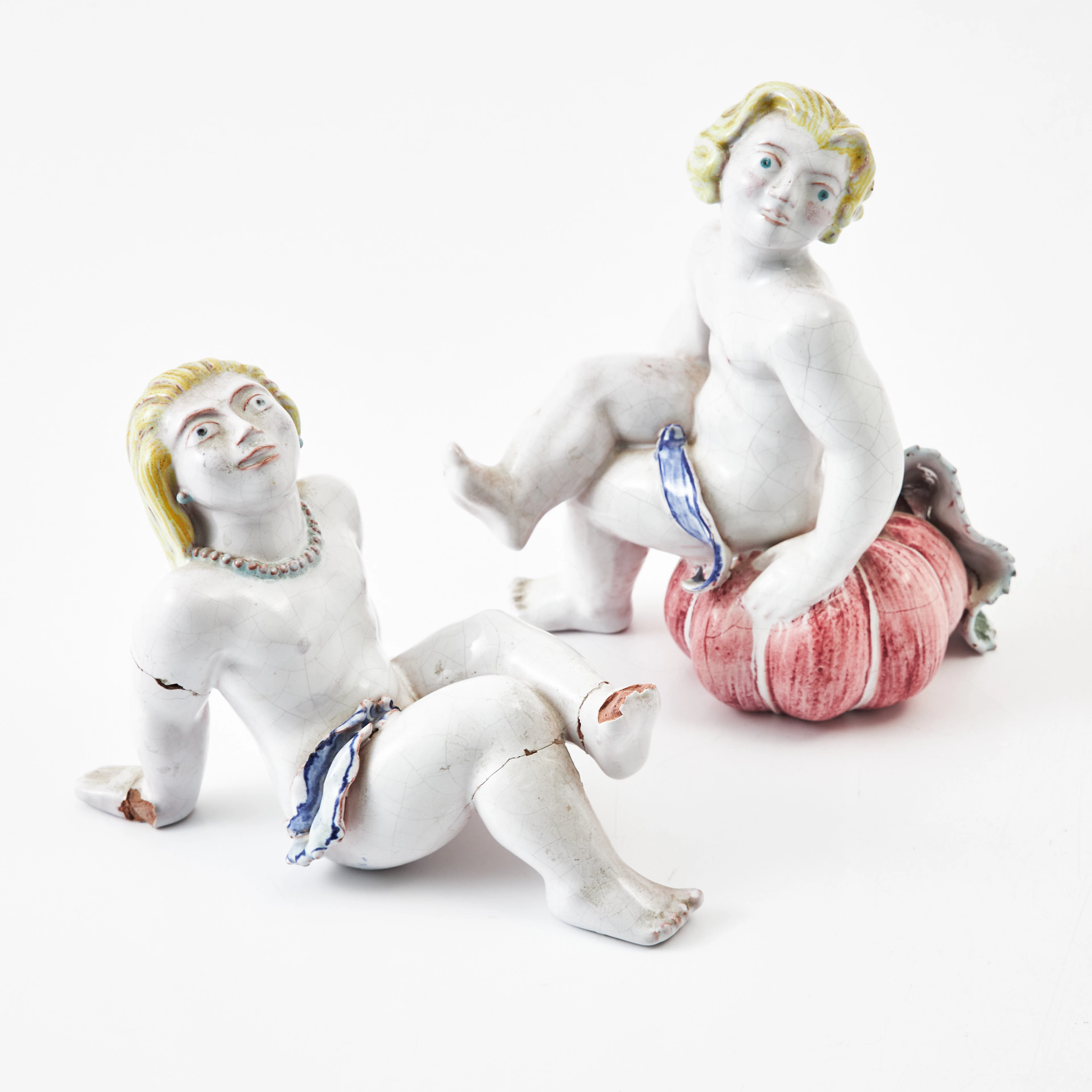 TYRA LUNDGREN. Figuriner, 2 st, glaserat lergods, i form av putti, Rörstrand.