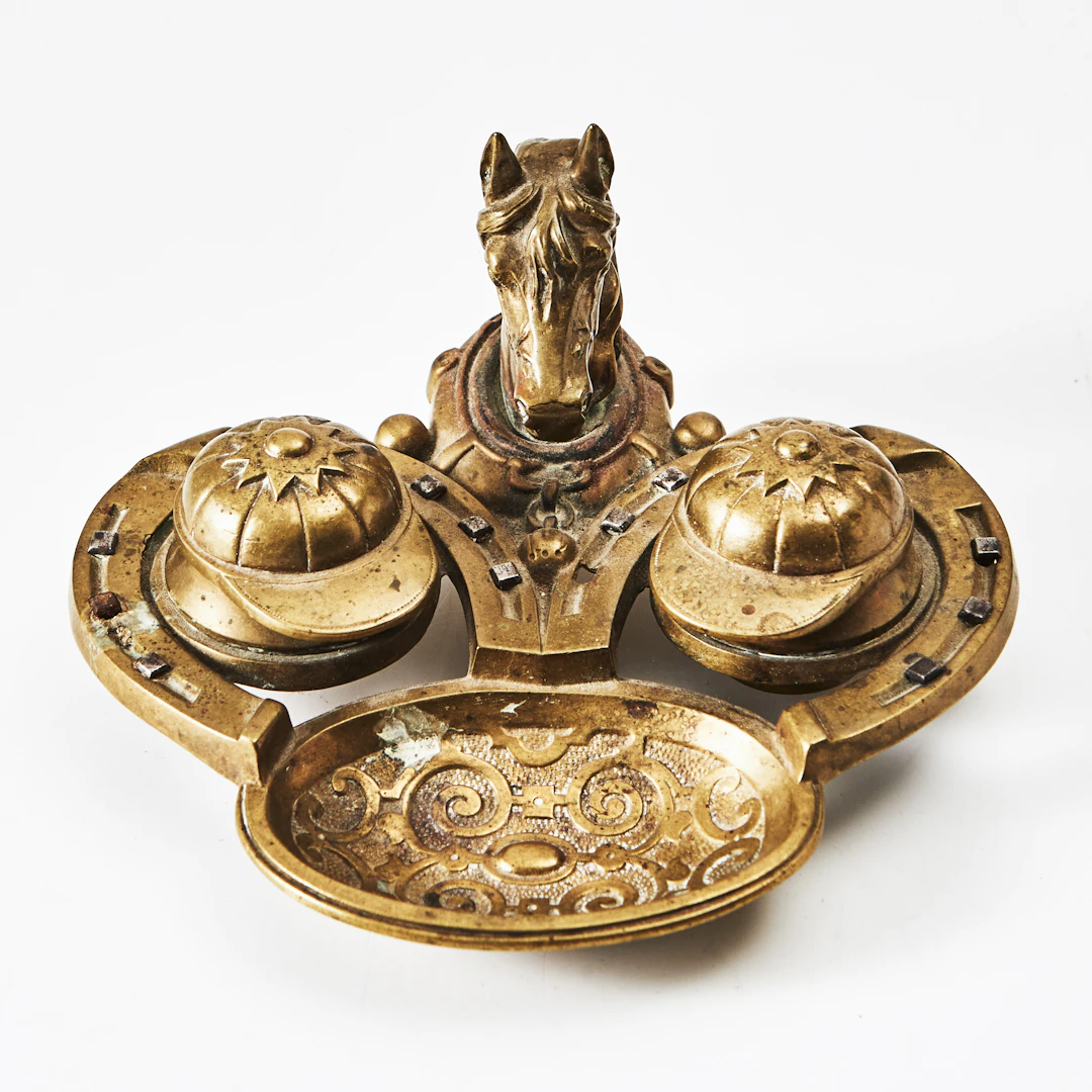 BLÄCKSTÄLL, brons, 1900-talets början, dekor av hästhuvud och jockeykepsar.