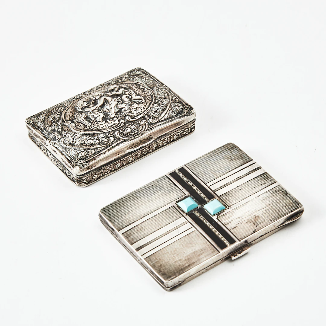 CIGARETTETUIER, 2 st, silver, varav en med dekor av turkoser av Karl