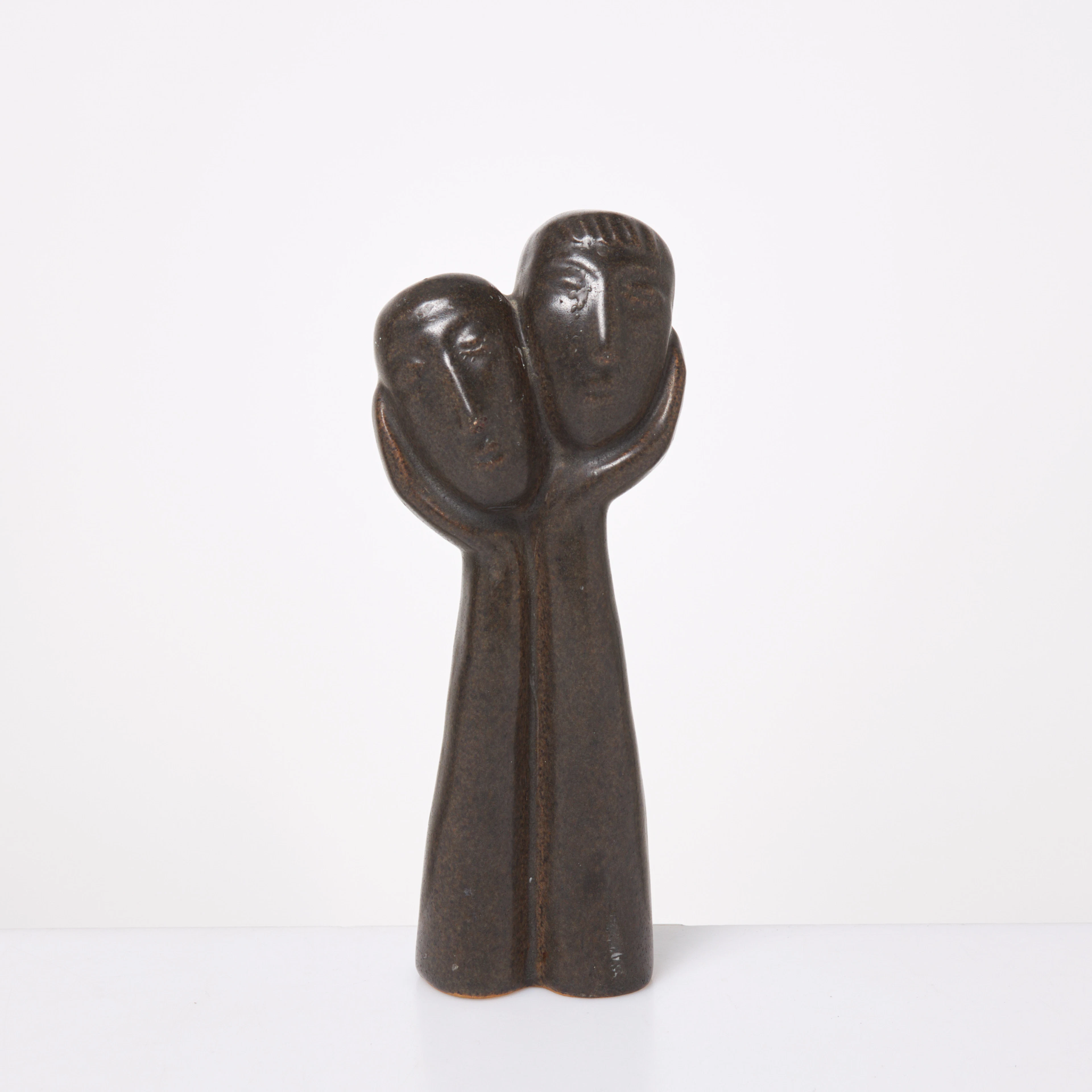 ÅKE HOLM. Skulptur, två huvuden i armar, glaserat stengods, signerade i godset.