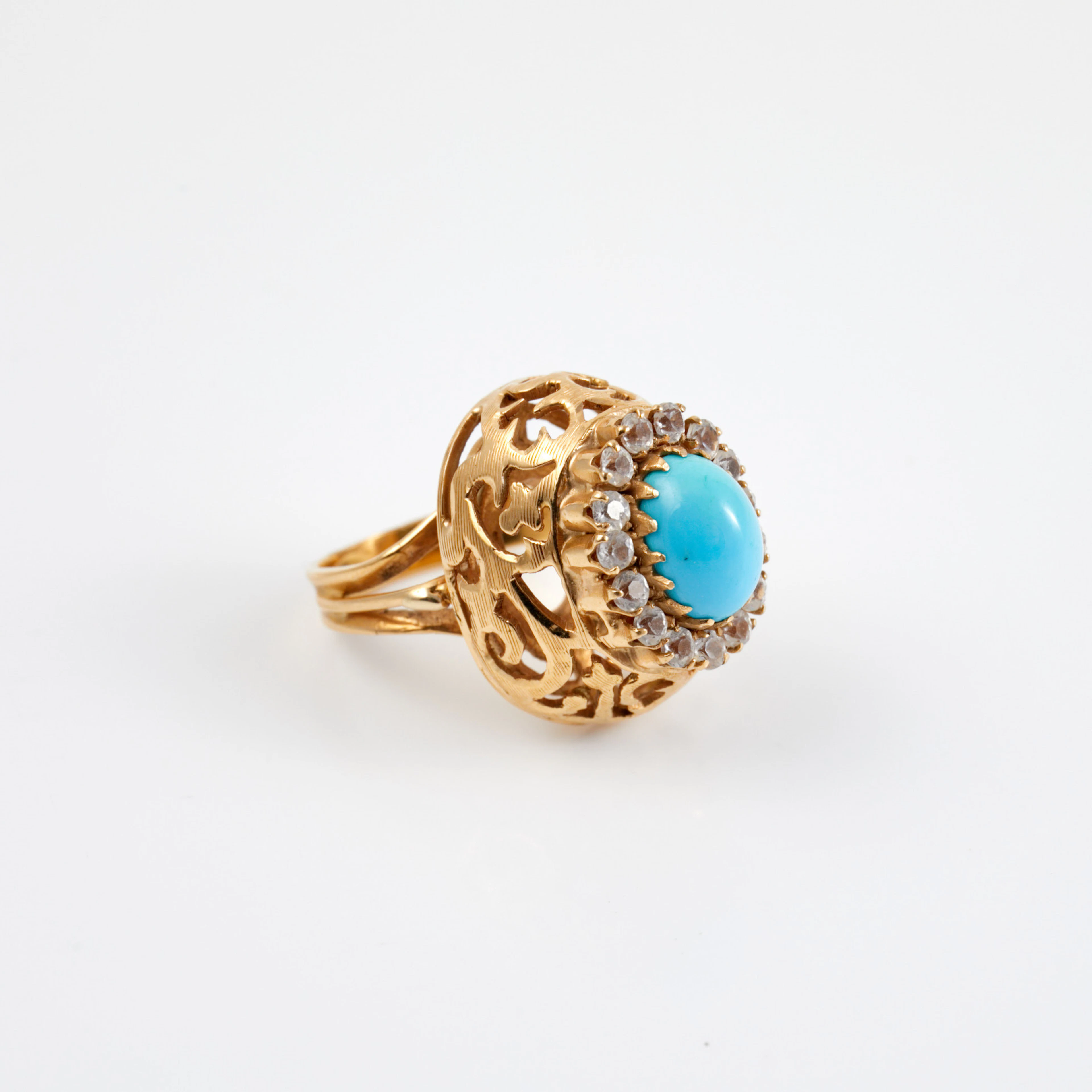 RING, 18 k guld, 1 cabochonslipad turkos, bekransad av syntetiska vita safirer.