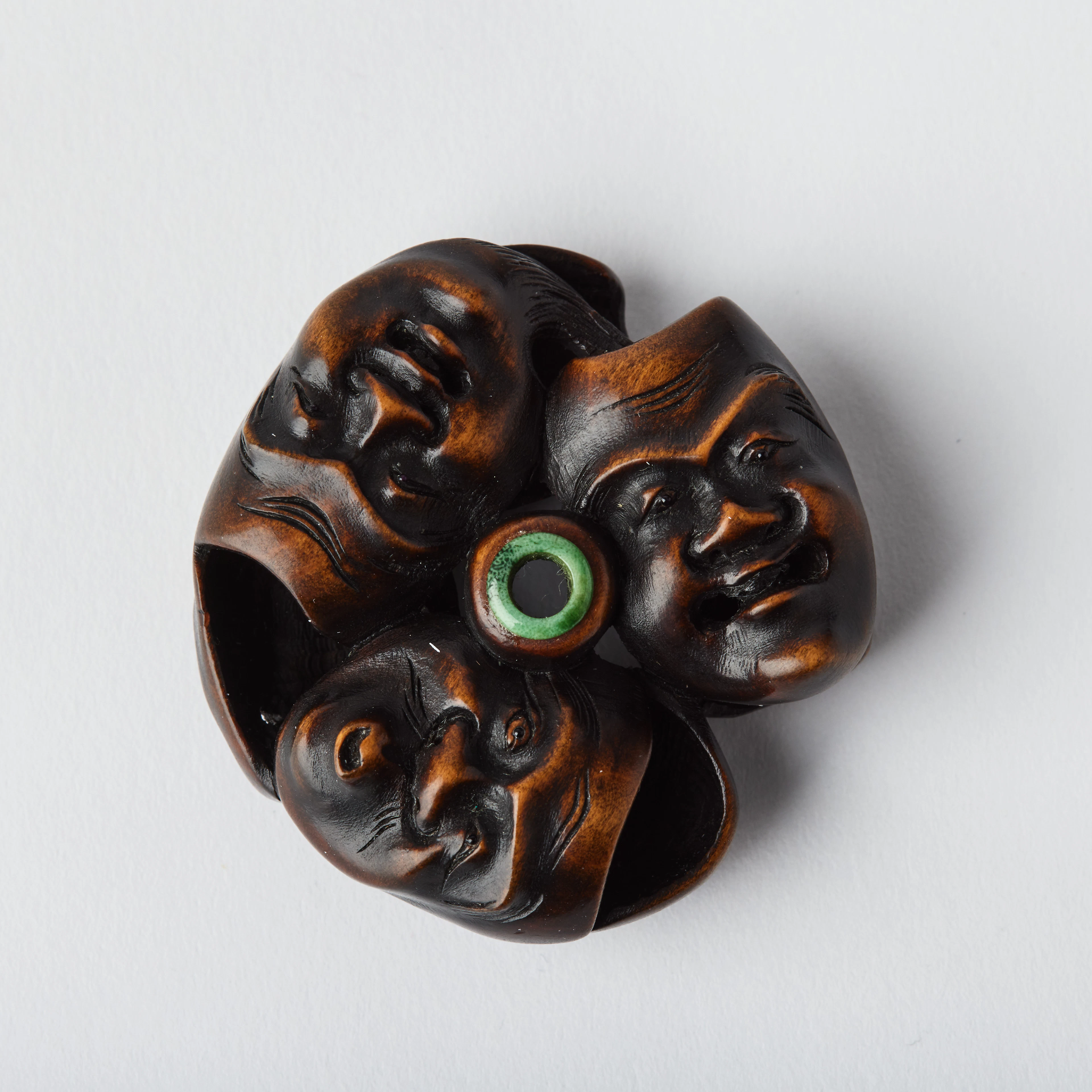 A Japanese Boxwood Netsuke of a Group of Masks.