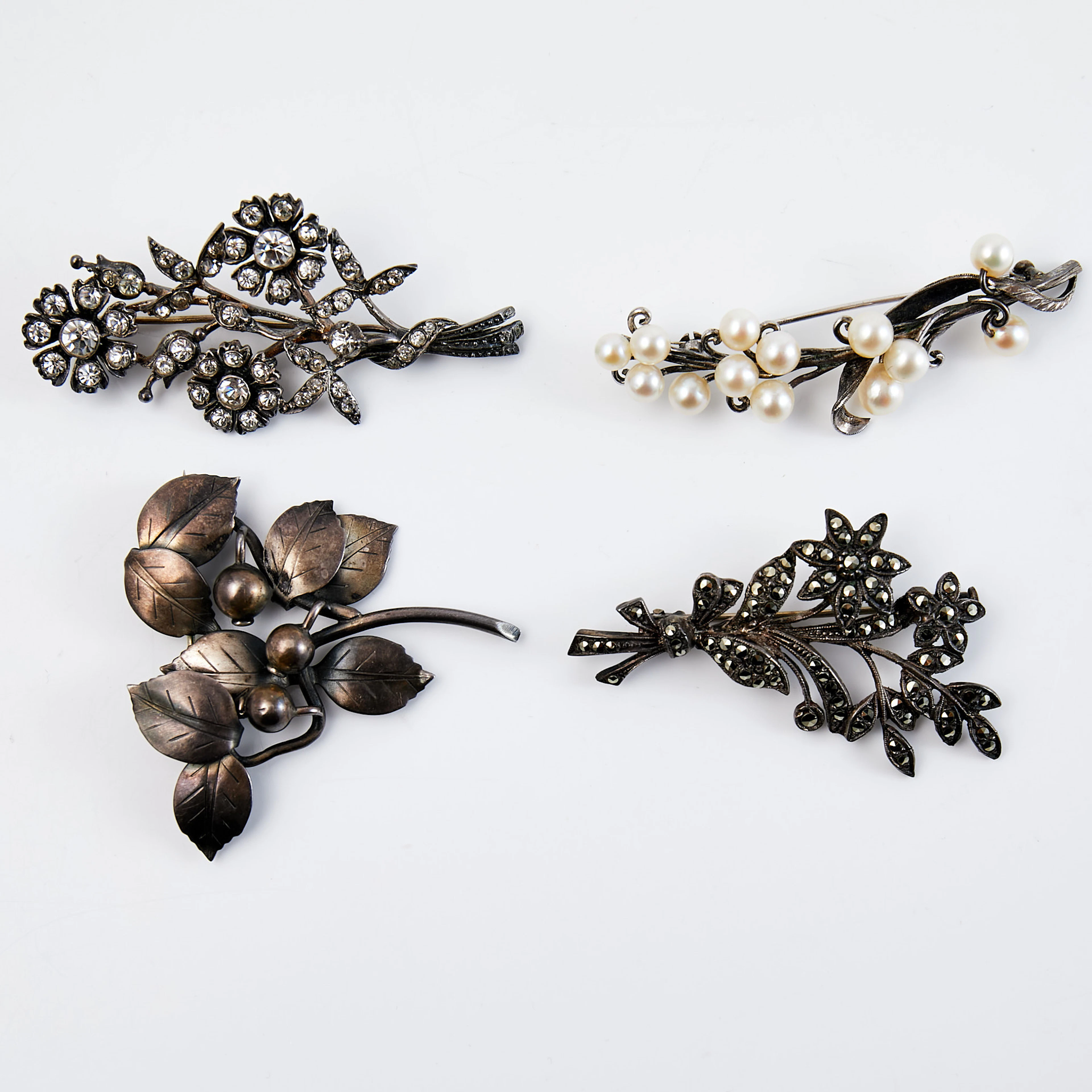 BROSCHER, 4 st, silver, i form av stiliserade blommor och blad, dekor