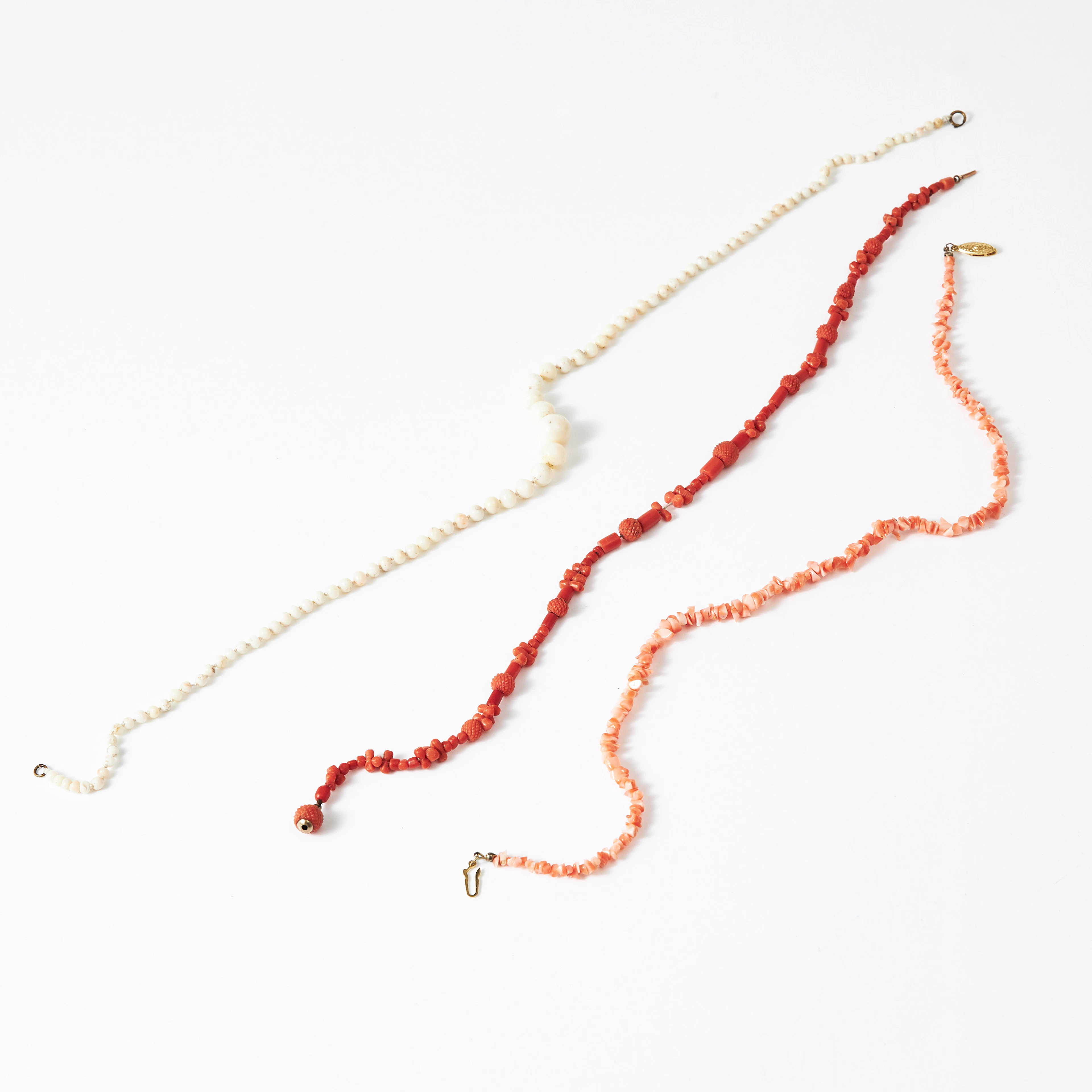 HALSBAND, 3 st., vit resp. orange korall, varav ett med skurna kulor