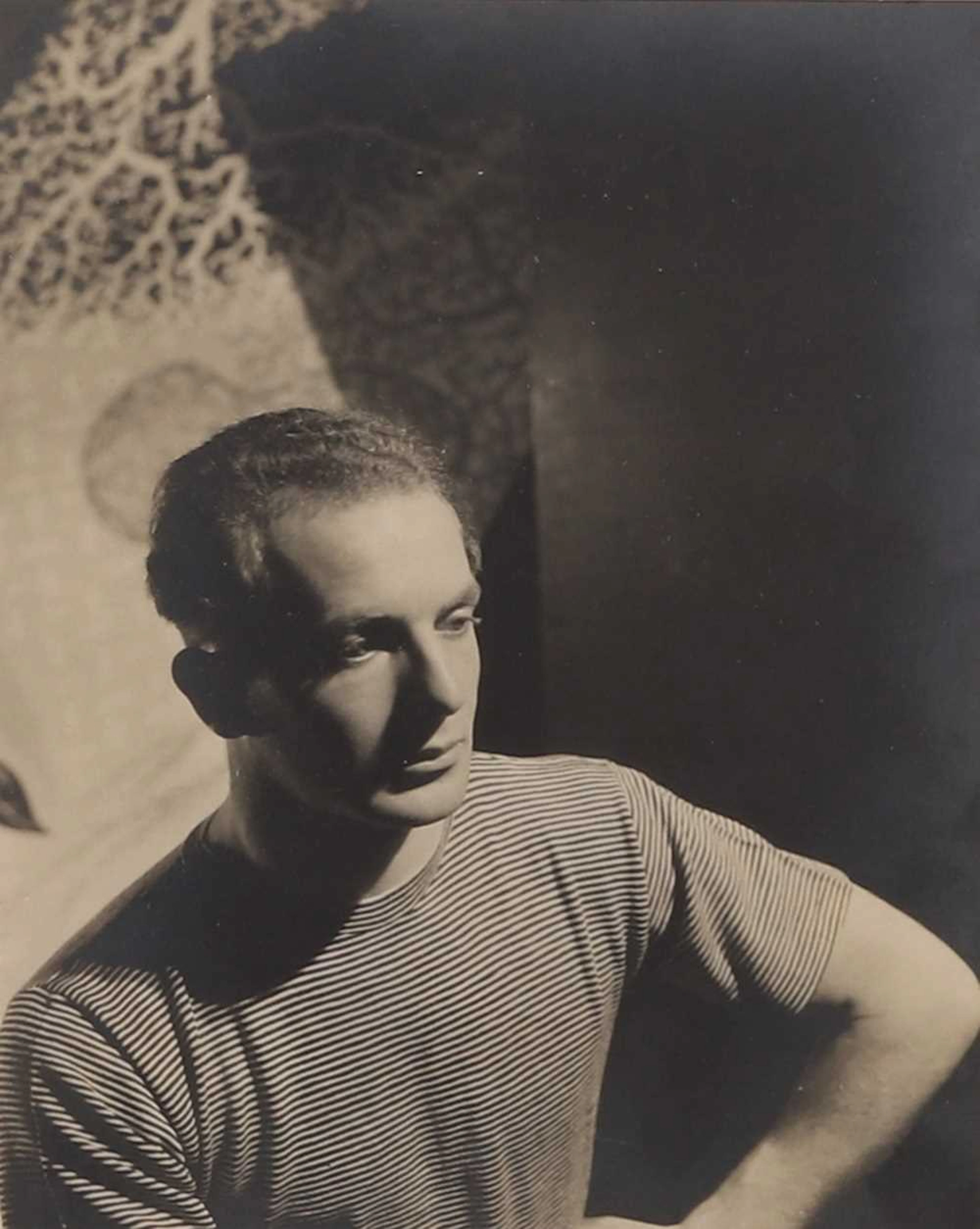 A photograph of Humphrey Spender in front of a John Banting painting