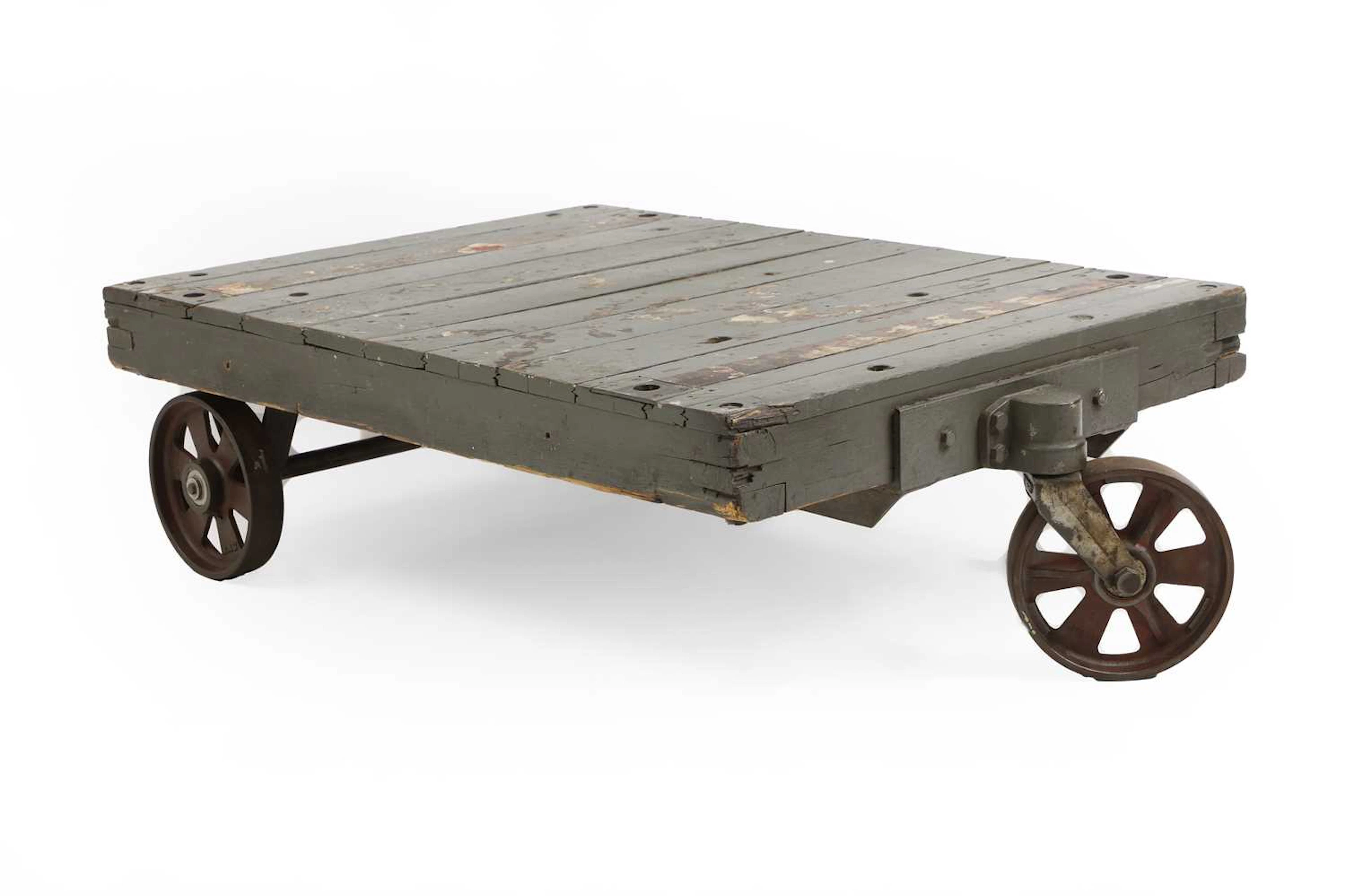A grey painted industrial three wheel coffee table