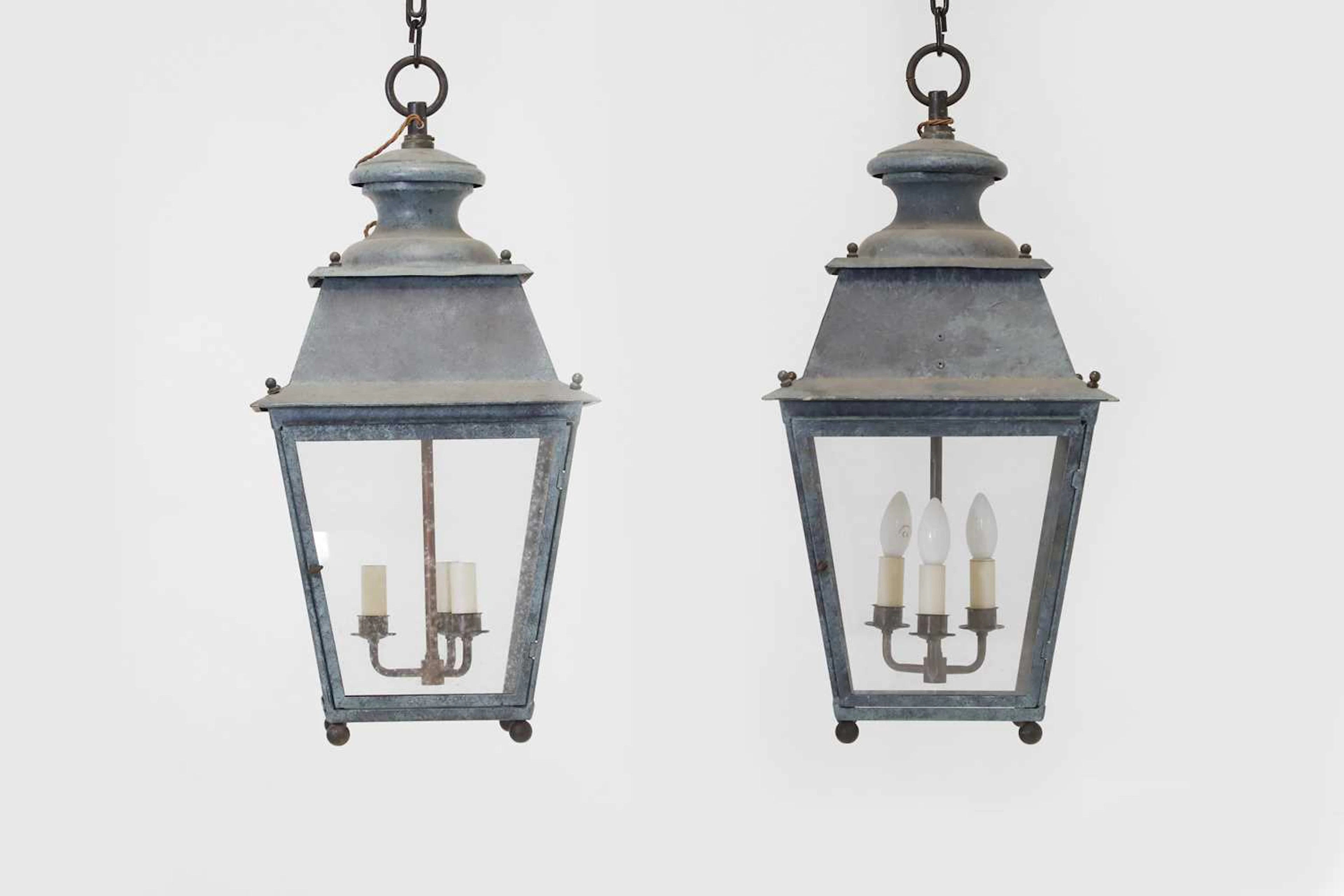 A pair of patinated metal lanterns