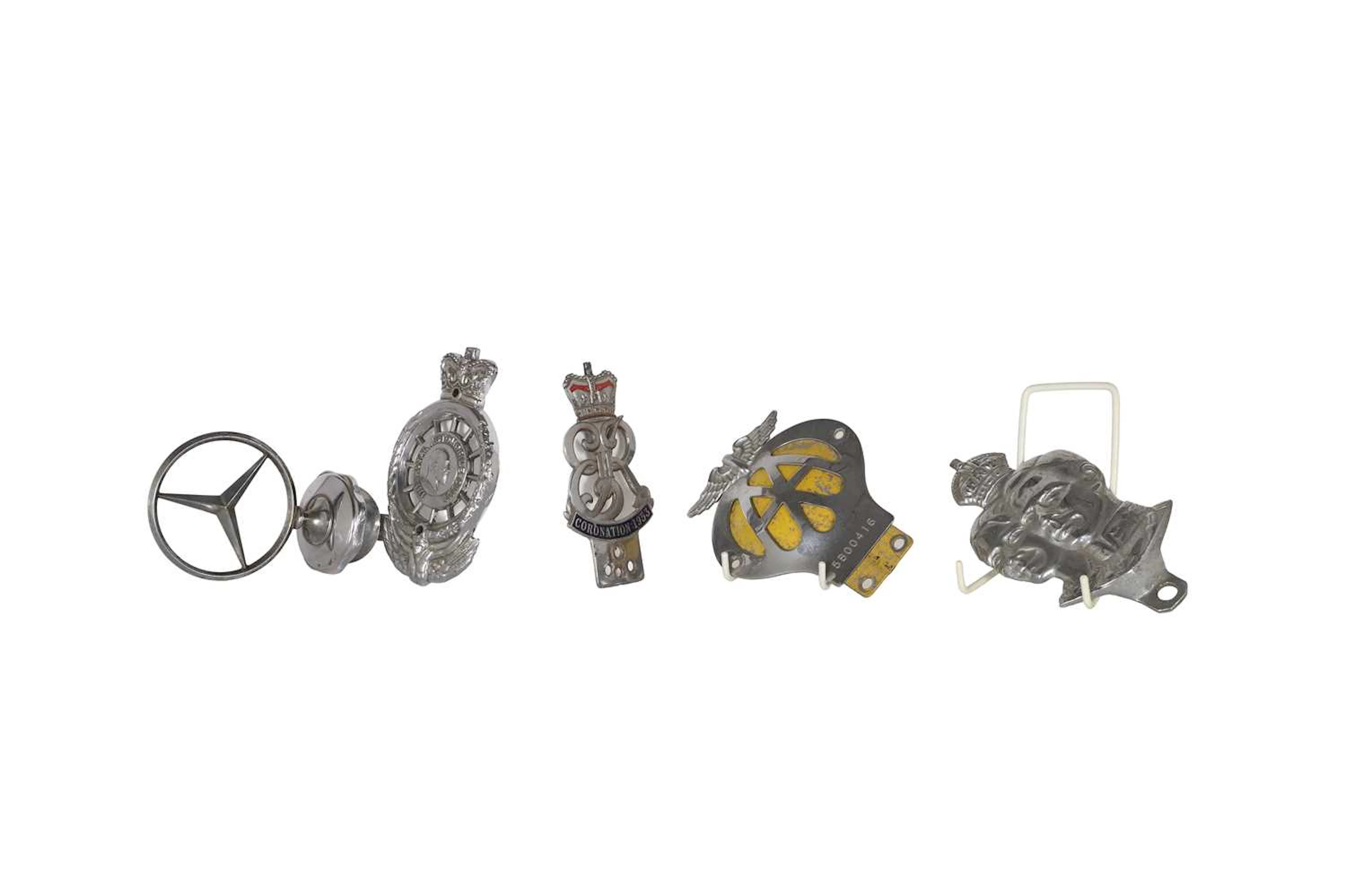 A group of badges and a mercedes mascot