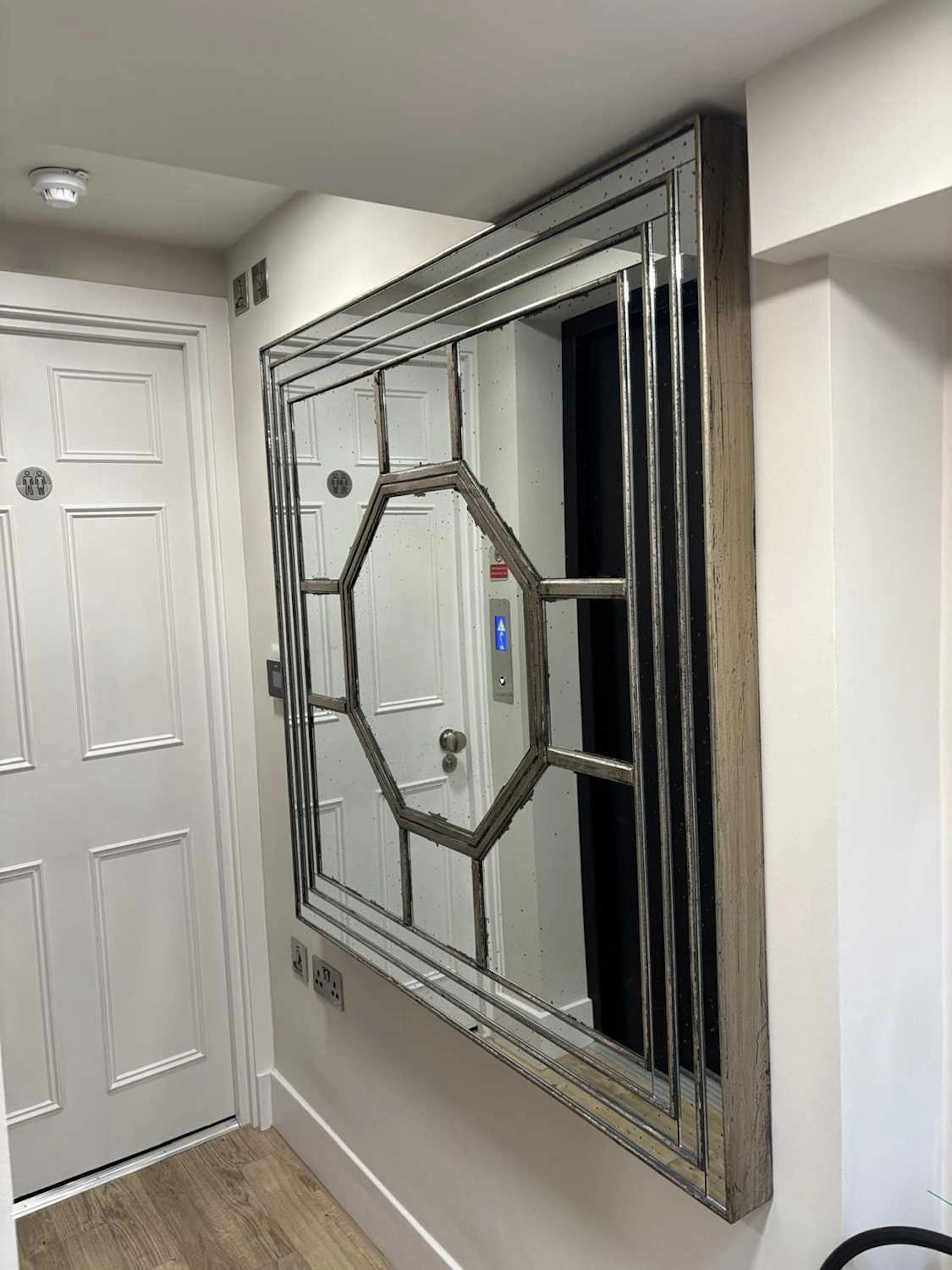 A large square silvered wall mirror by OKA of recent manufacture